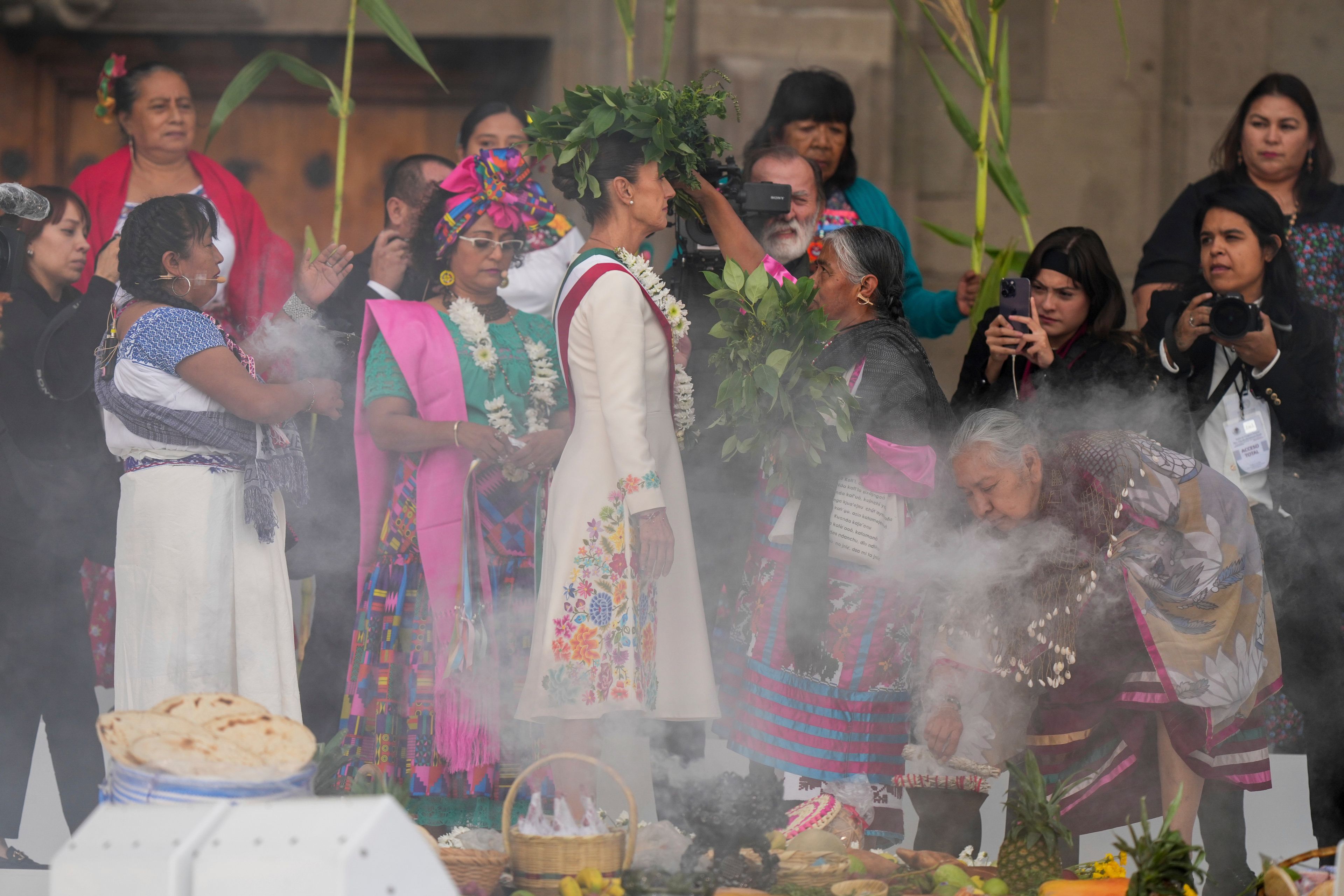 Indigenous women carry out a traditional ceremony for President Claudia Sheinbaum in the Zocalo, Mexico City's main square, on her inauguration day, Tuesday, Oct. 1, 2024. (AP Photo/Fernando Llano)