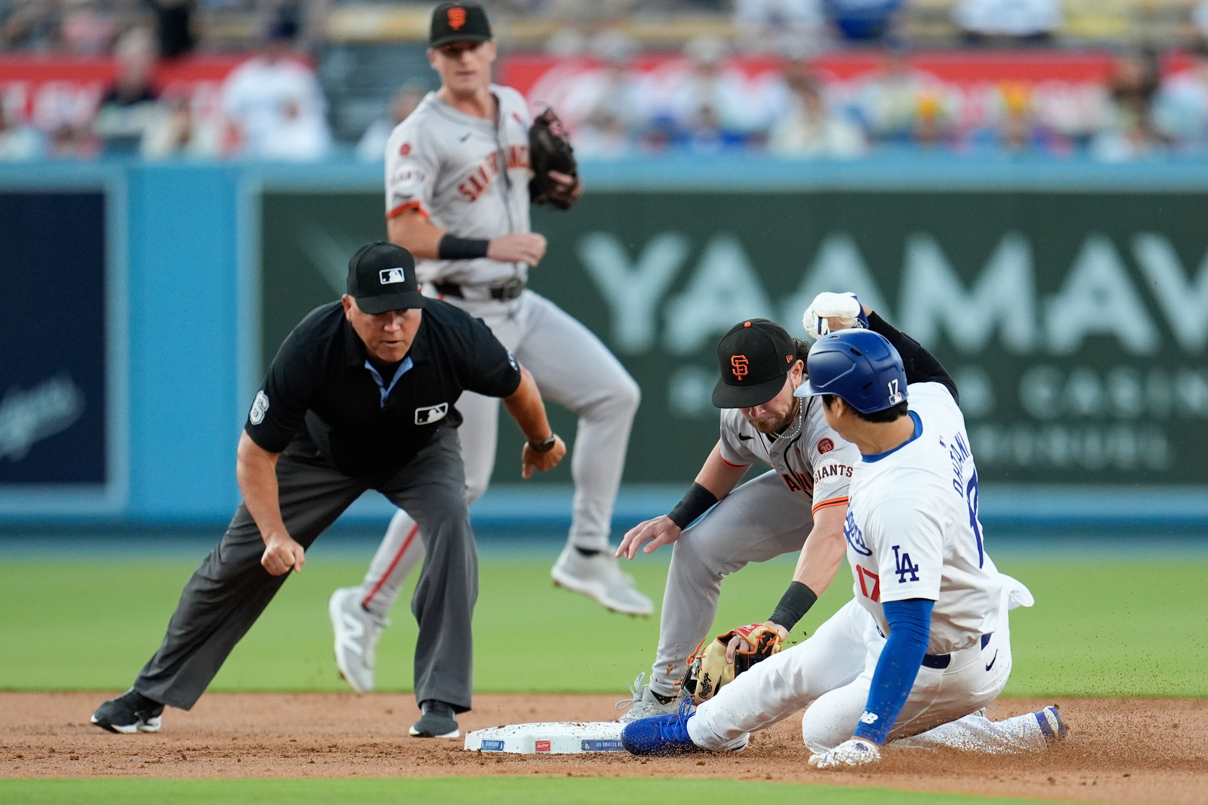 San Francisco Giants second baseman Brett Wisely, second from right, tags out Los Angeles Dodgers' Shohei Ohtani, right, on a steal-attempt during the first inning of a baseball game Monday, July 22, 2024, in Los Angeles. (AP Photo/Marcio Jose Sanchez)