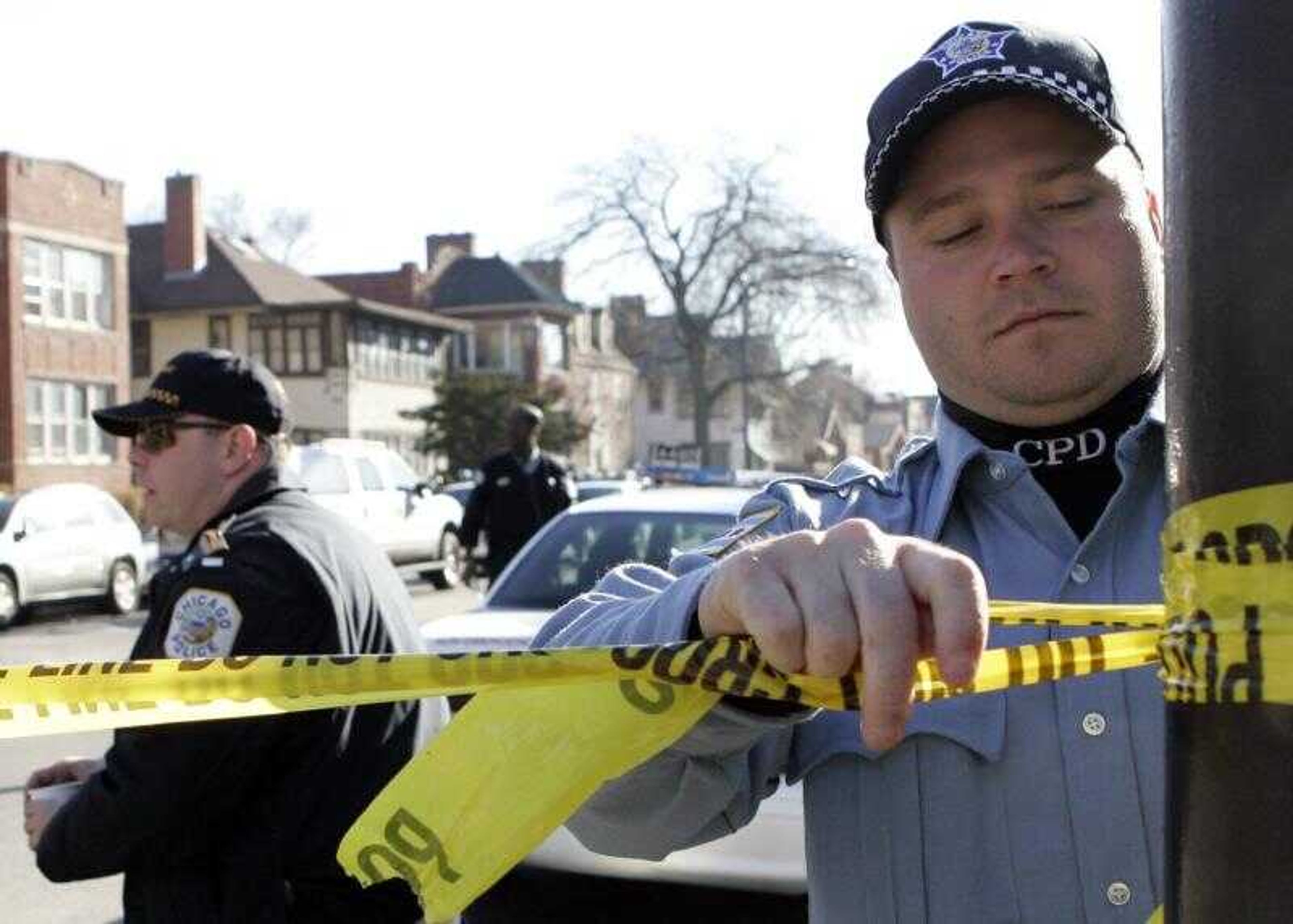 A Chicago police official re-taped a police line at apartment standoff Thursday.<br>Nam Y. Huh<br>Associated Press