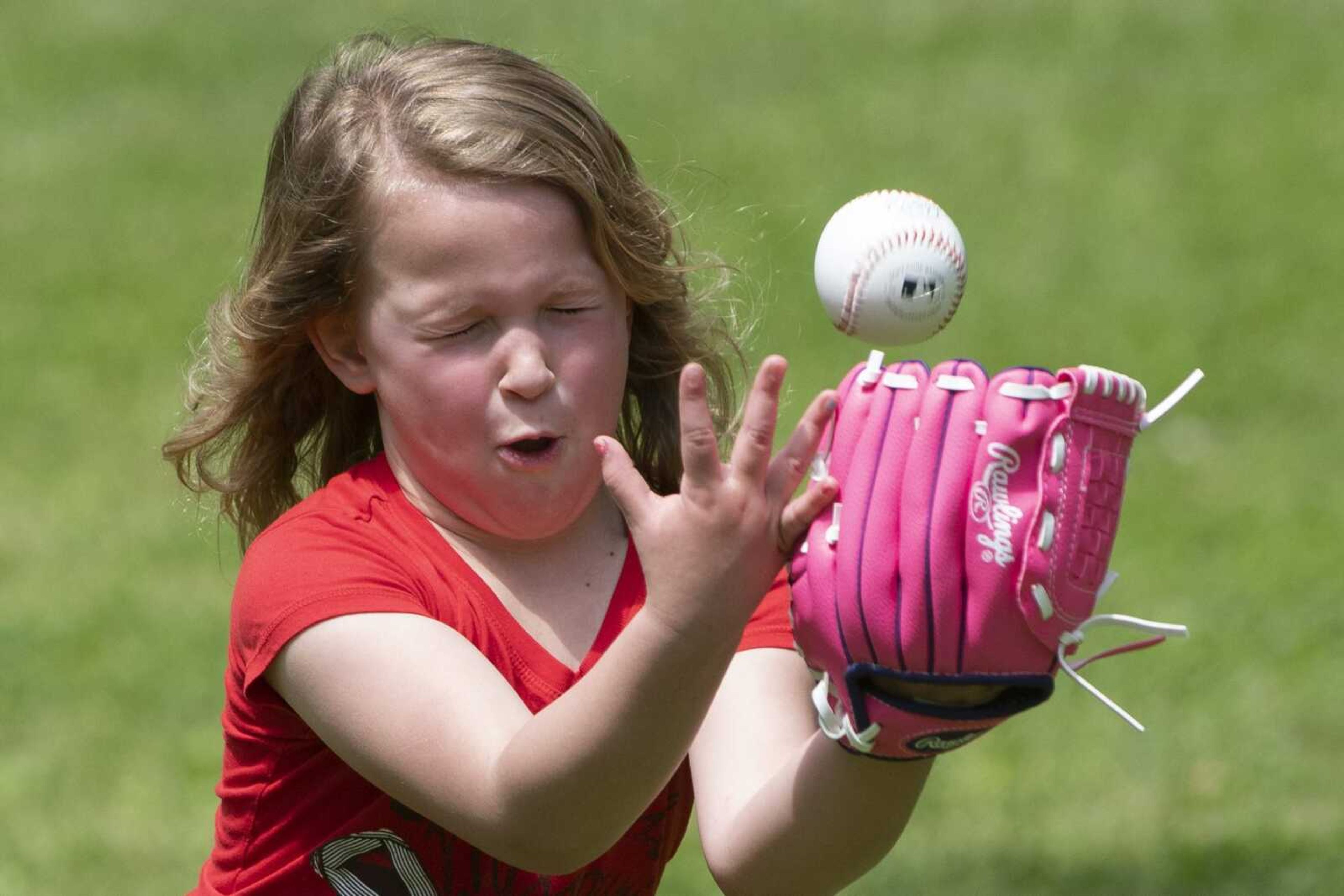 Allie Cook of Cape Girardeau, 4, attempts to catch the ball while working on her tee-ball skills with her twin sister, Abbie Cook, and grandparents, Steve and Easy Stilson of Cape Girardeau, on April 23 at Capaha Park in Cape Girardeau.