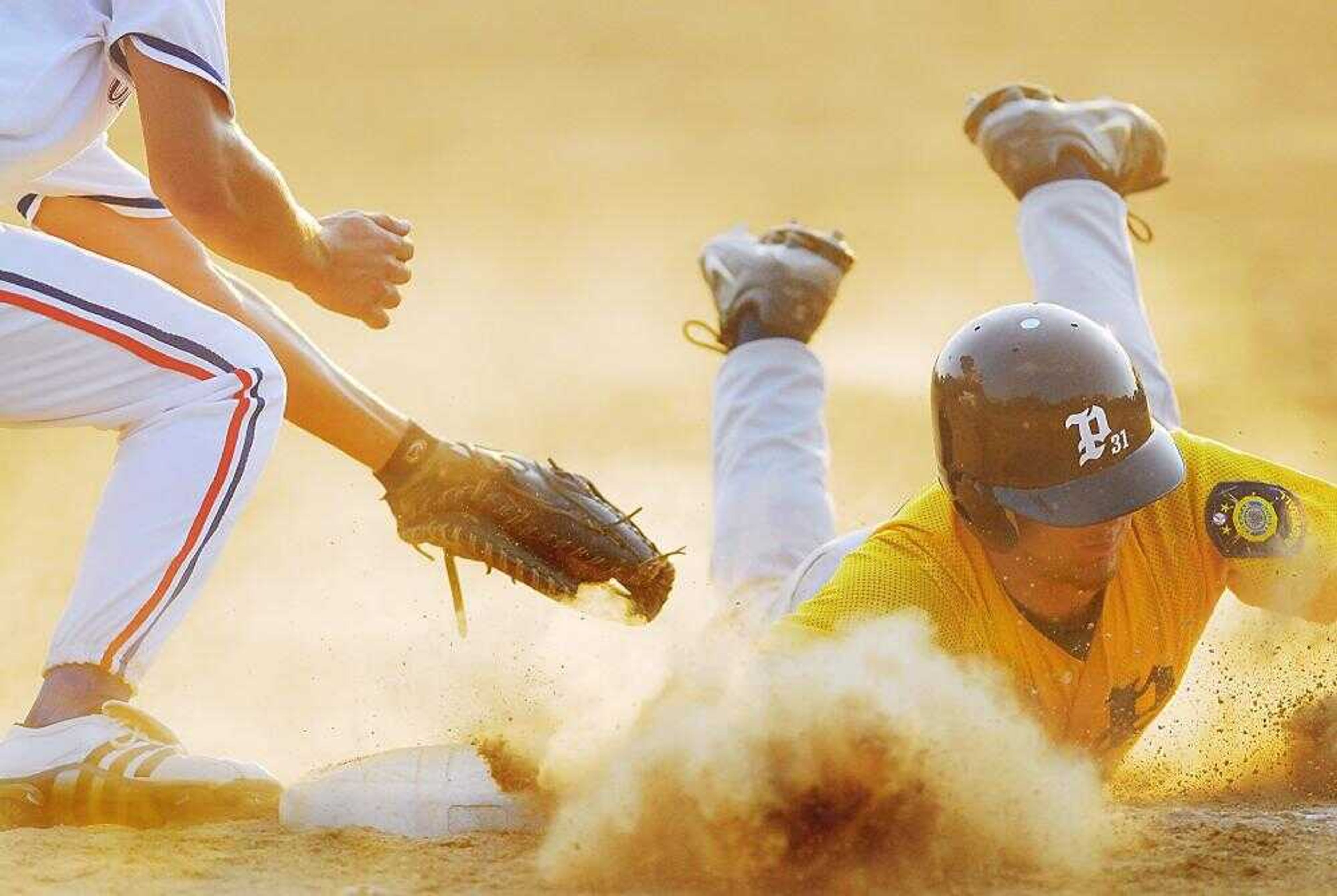 Paducah's Nick Logsdon slid under the tag by Cape first baseman Cody Tellor on a pickoff throw during the fifth inning of the first game at Capaha Field on Wednesday. (AARON EISENHAUER ~aeisenhauer@semissourian.com)