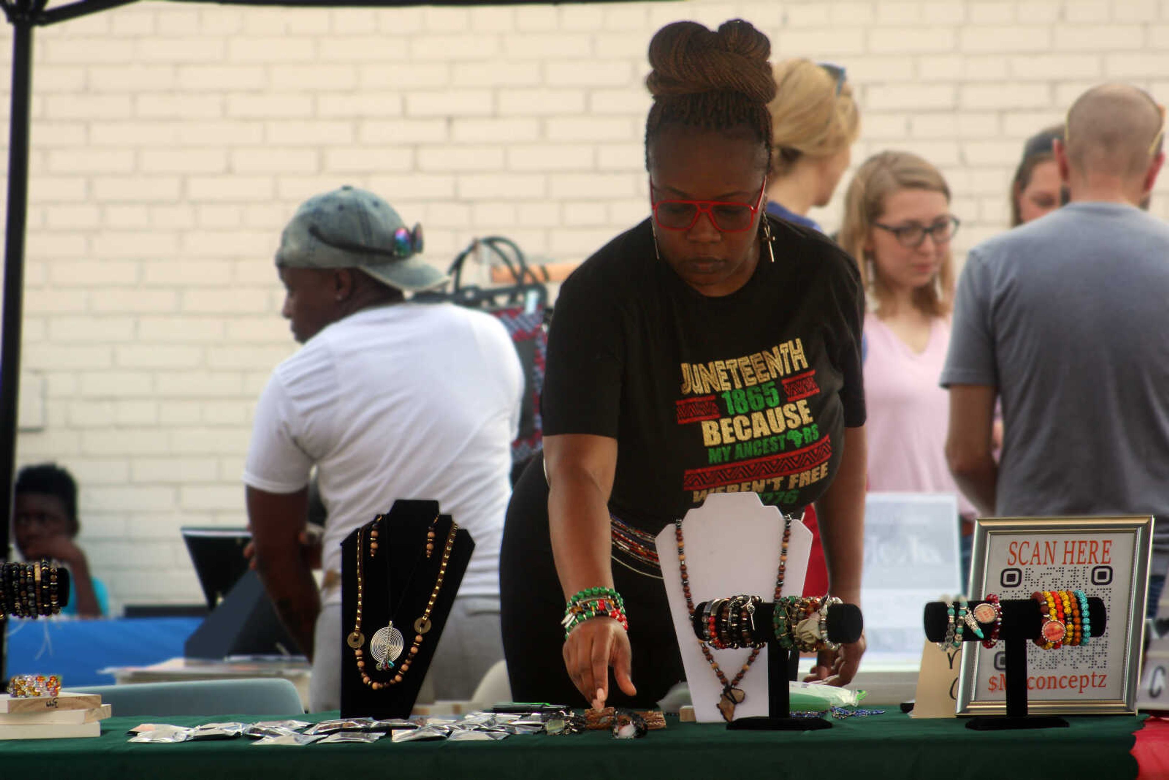 Monet L., artist and designer at Mo Conceptz Artisan Jewelry, arranges jewelry on her table during One City's second annual Juneteenth Celebration on Saturday, June 19, 2021, in Cape Girardeau. Mo Conceptz Artisan Jewelry was one of 28 vendors to participate in this year's celebration, held in the parking lot of One City.