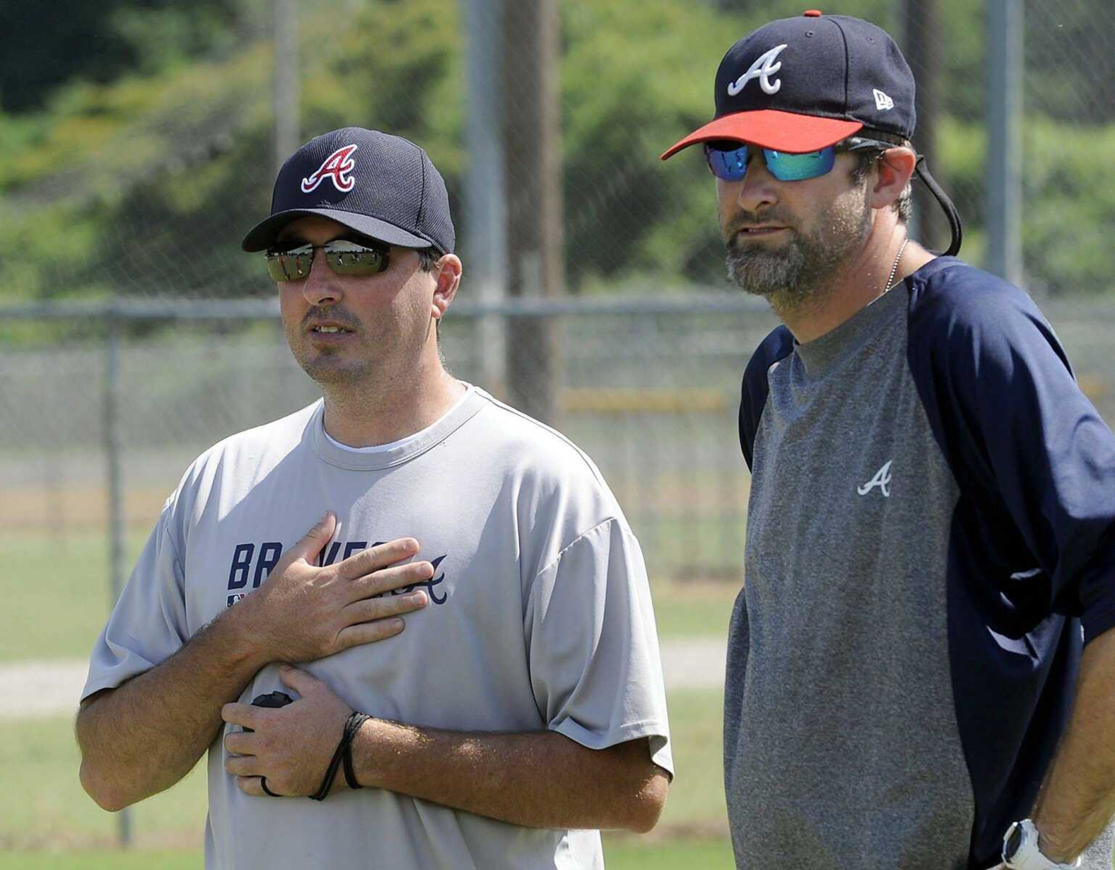 Terry Tripp, left, and Jon David French watch baseball prospects during drills at an Atlanta Braves tryout Wednesday in Kennett, Mo. (Fred Lynch)