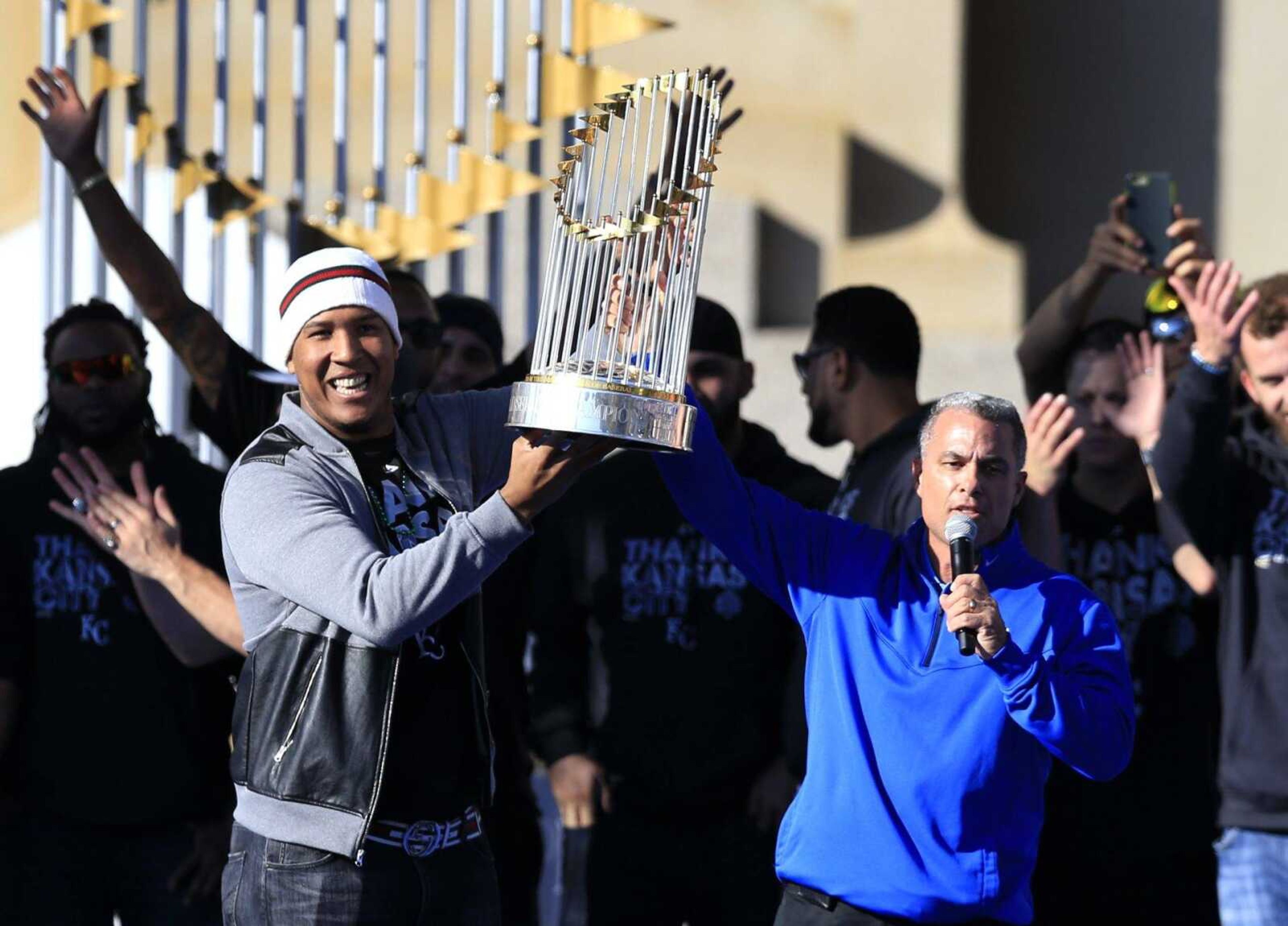 Royals catcher Salvador Perez, the World Series MVP, and general manager Dayton Moore, right, hold the championship trophy during a rally Tuesday in Kansas City, Missouri. (Orlin Wagner ~ Associated Press)