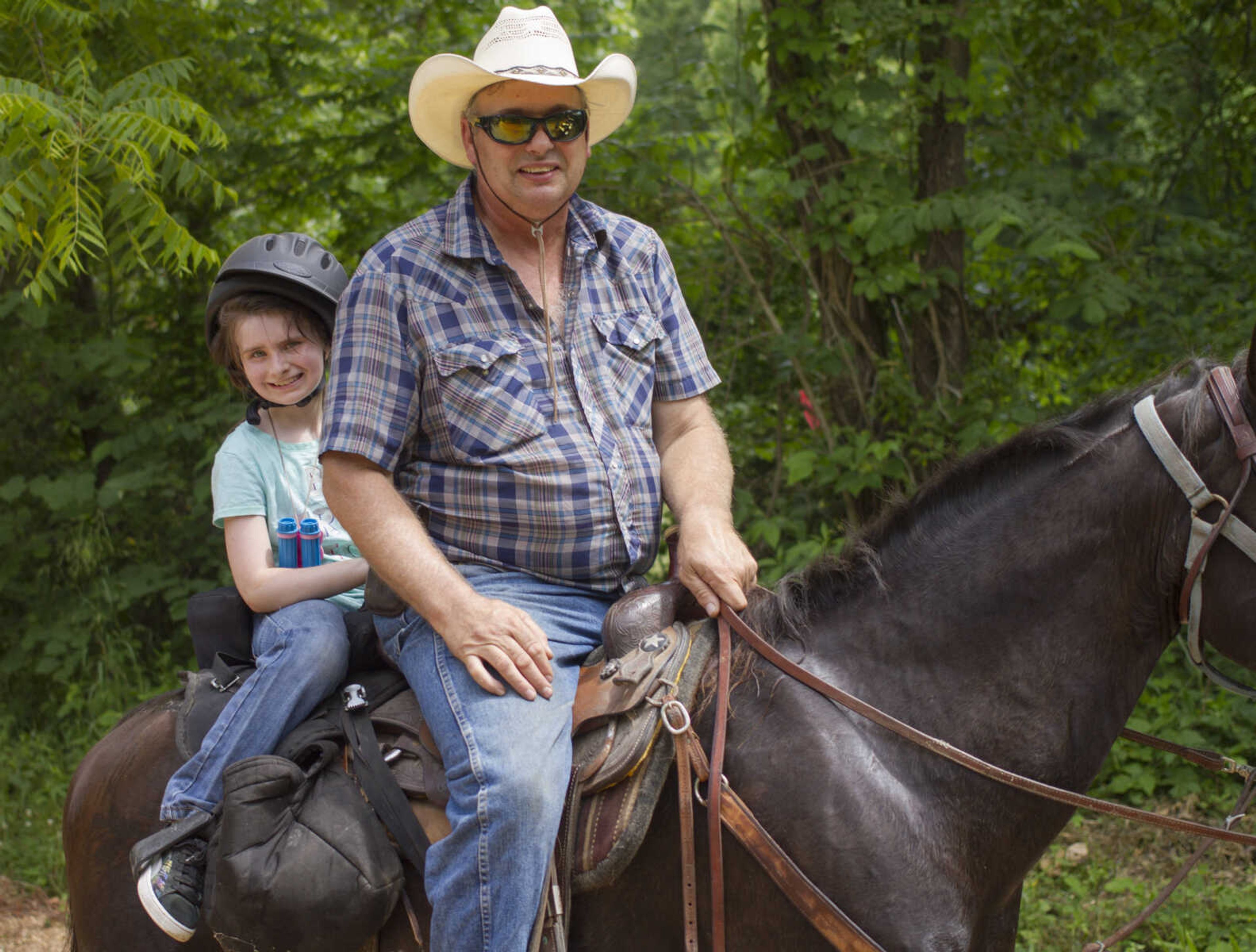 Addison Taylor, left, 8, poses for a photo with her father, David Taylor, during a trail ride sponsored by the Jackson Riding Club June 4, 2017 in Patton, Missouri.