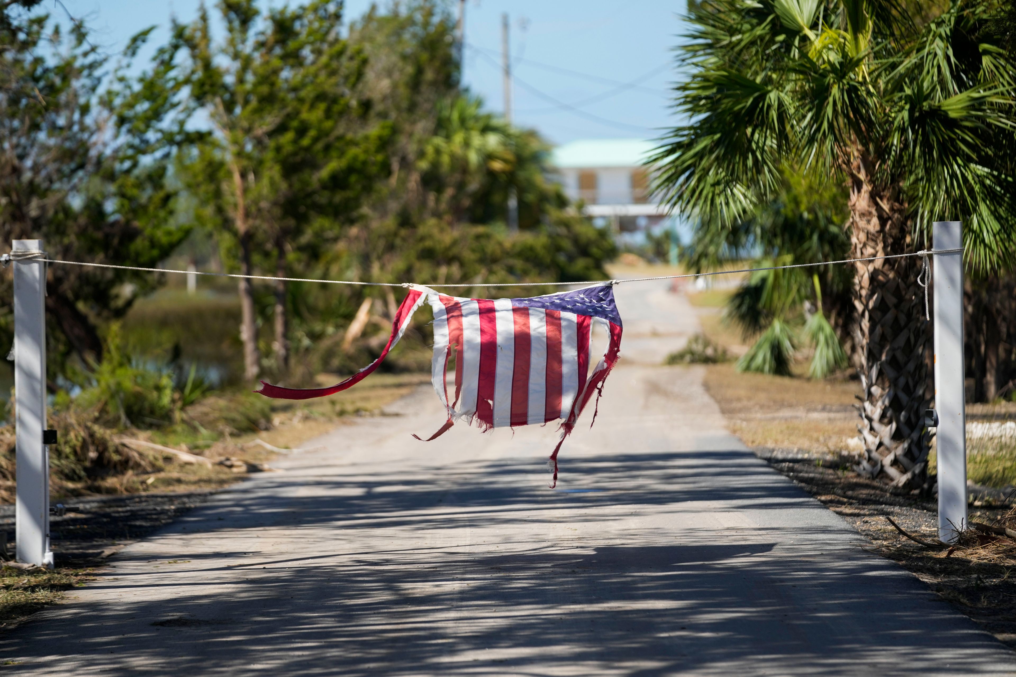 A tattered American flag hangs on a rope on a now closed road in the aftermath of Hurricane Helene, in Jena, Fla., Sunday, Sept. 29, 2024. (AP Photo/Gerald Herbert)