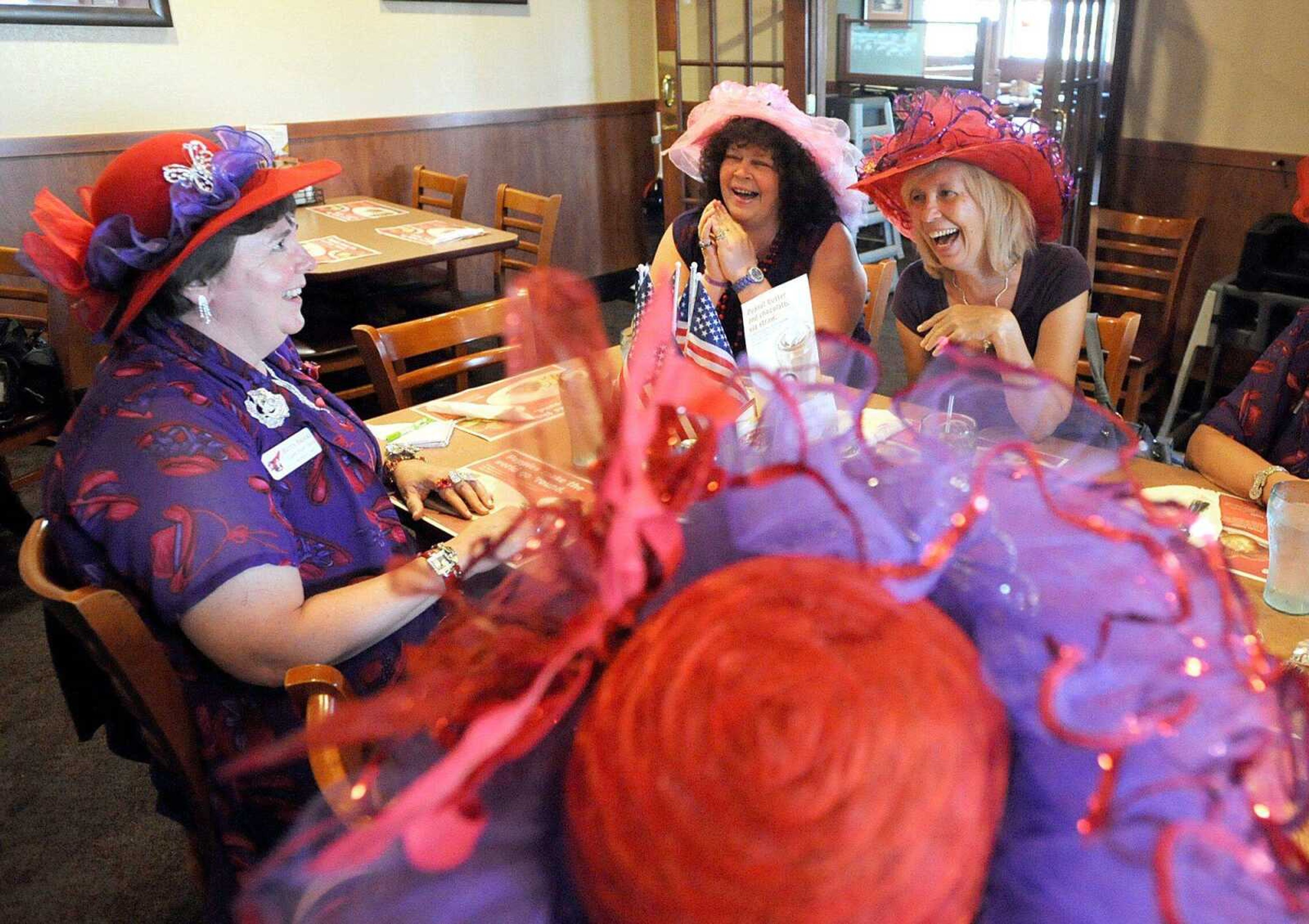 From left, Betty Brooks, Kim Foulk and Cindy Pfefferle share a laugh Tuesday, May 29, 2012 during the monthly meeting of the Classy Sassy Chicks chapter of the Red Hat Society (Laura Simon)