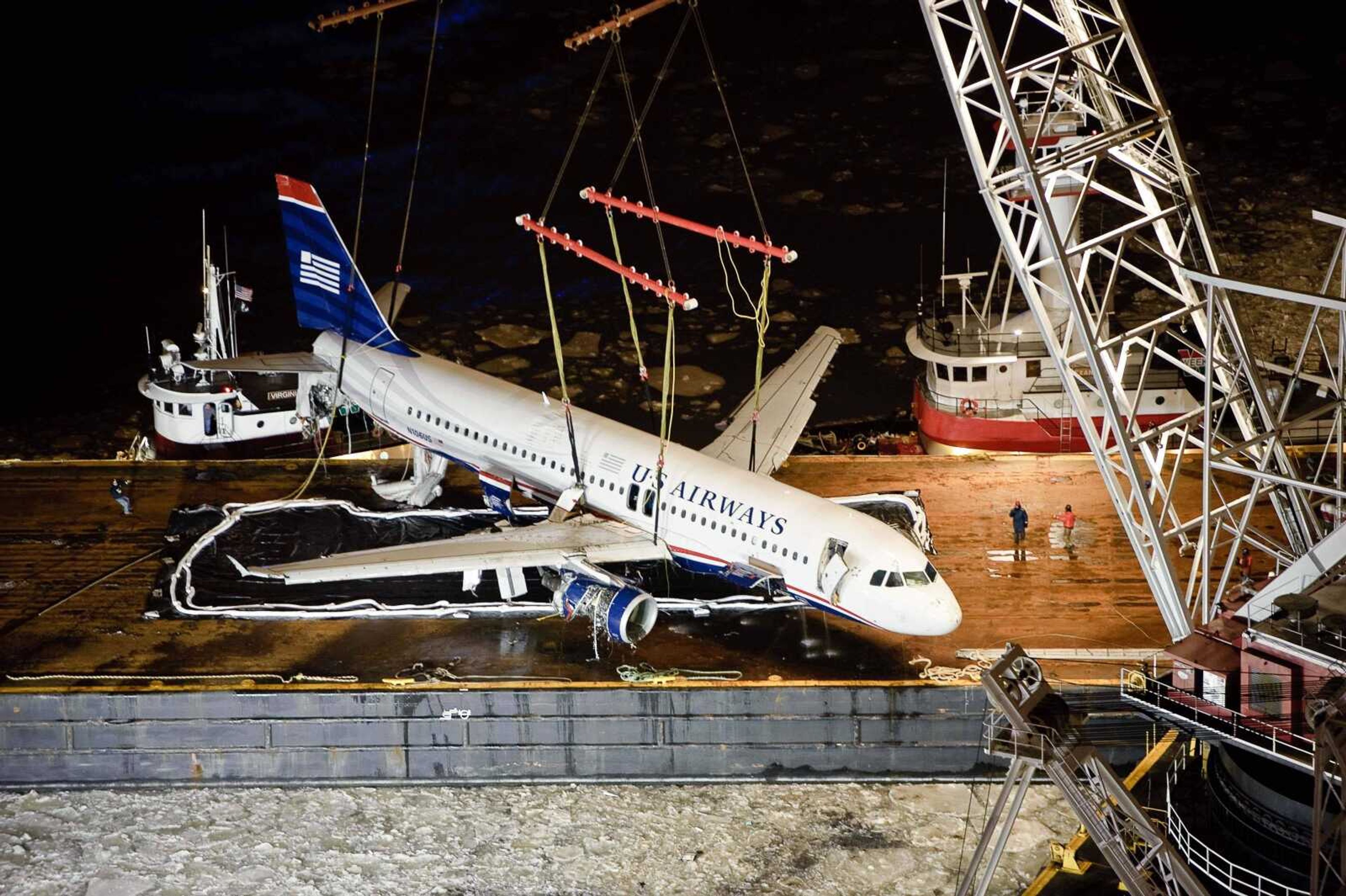 Alexandre Valerio ~ Associated Press<br>US Airways Flight 1549 is lowered on to a barge after it was recovered late Saturday from the Hudson River in New York. The aircraft was moved to New Jersey for inspection by National Transportation Safety Board investigators.