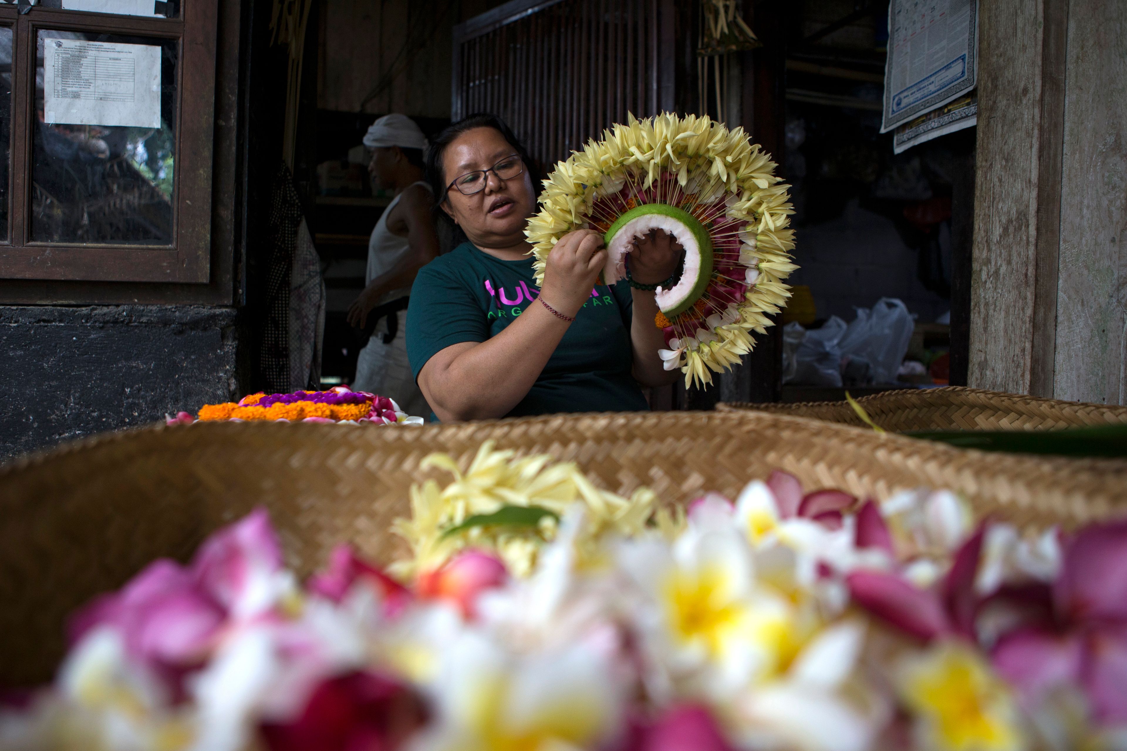 Kadek Krisni prepares a headgear for her daughter to participate in Rejang Pucuk at Geriana Kauh village, Karangasem, Bali, Indonesia on Thursday, Nov. 21, 2024. (AP Photo/Firdia Lisnawati)