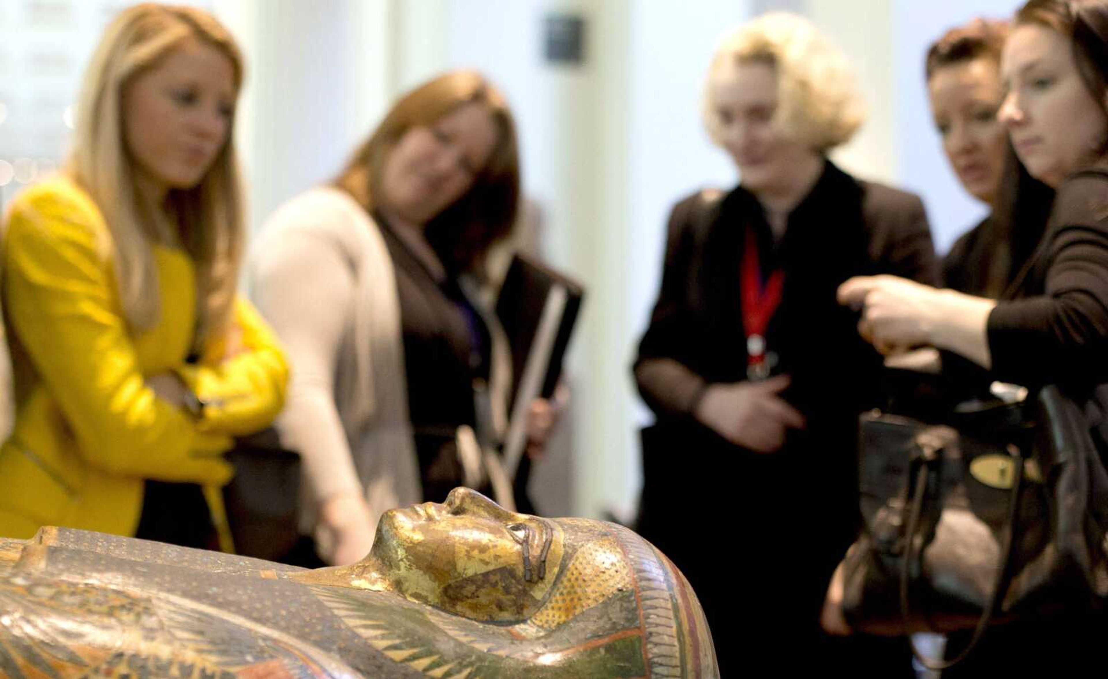 Members of the media stand around the Mummy of Tamut, a temple singer around 900 B.C., during a news conference Wednesday at the British Museum in London. Scientists at the British Museum have used CT scans and volume graphics software to go beneath the bandages, revealing the skin, bones, internal organs and, in one case, a brain-scooping rod left inside a skull by embalmers. The results are going on display in an exhibition that sets eight of the museum&#8217;s mummies alongside detailed 3-D images of their insides. (Alastair Grant ~ Associated Press)