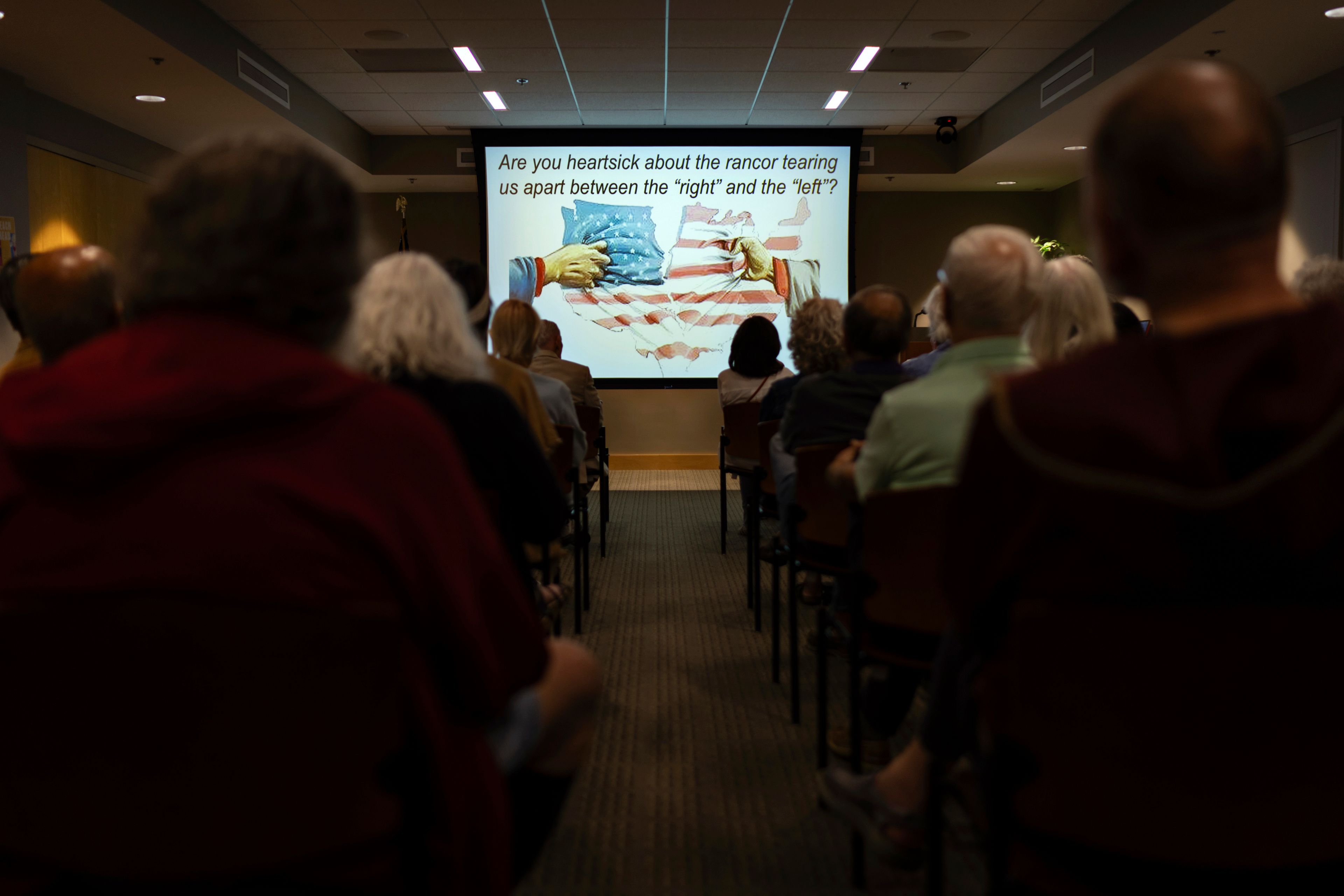 Attendees from across the political spectrum listen to a Braver Angels lecture on depolarization at the Rogers Free Library in Bristol, R.I., Thursday, Sept. 12, 2024. The non-profit organization holds workshops and mock debates across the country to help opposing political viewpoints communicate and understand each other's positions. (AP Photo/David Goldman)