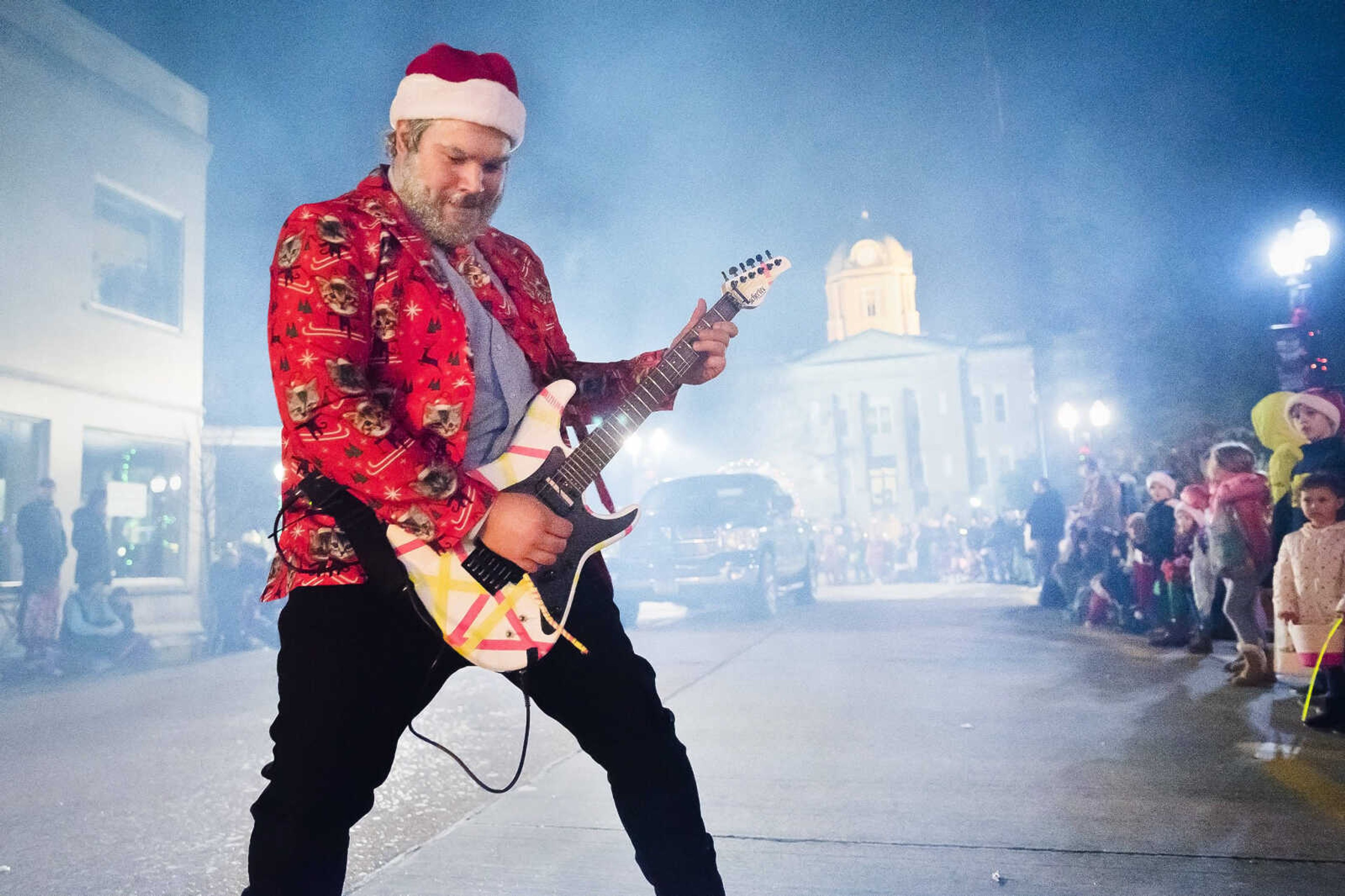 Kyle Fields plays an electric guitar and sends remotely amplified notes ringing throughout South High Street  while walking alongside the Jackson Audio & Music Supply float during the city's Christmas parade on Sunday, Dec. 8, 2019, in Jackson.