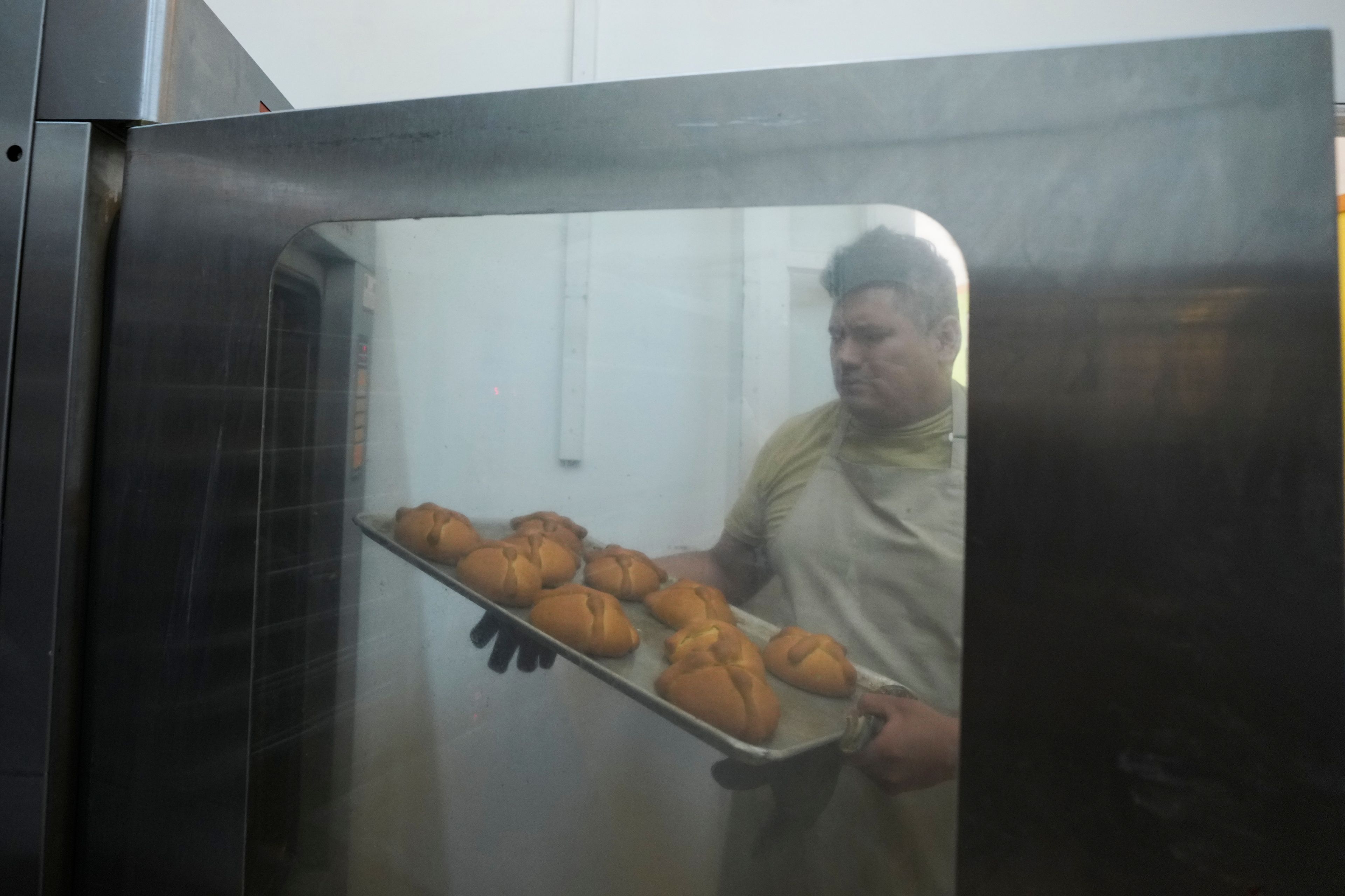 Victor Silverio prepares pan de muerto, or "bread of the dead," traditional for Mexico's Day of the Dead, at a bakery in the San Rafael neighborhood of Mexico City, Thursday, Oct. 17, 2024. (AP Photo/Fernando Llano)