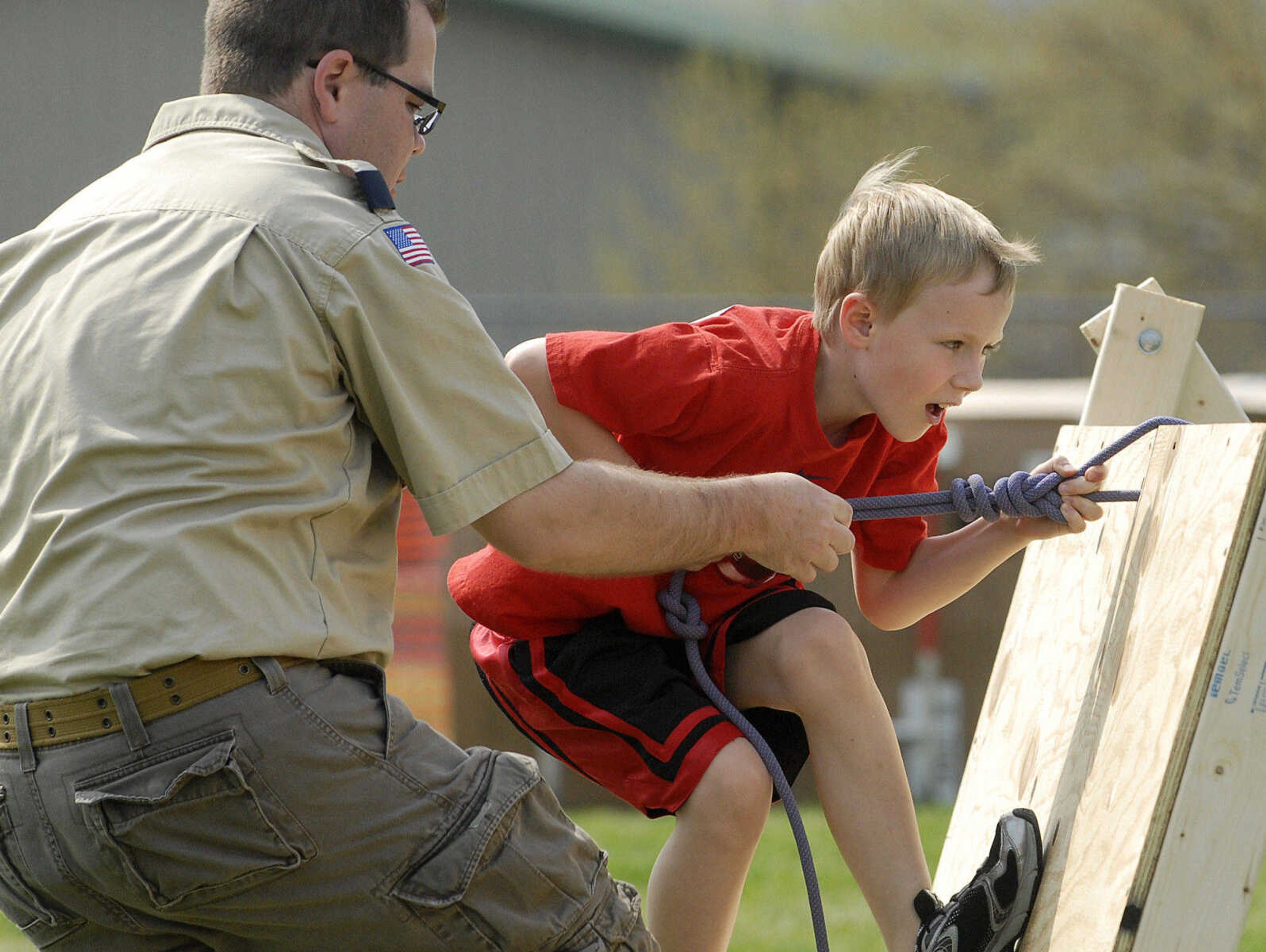 LAURA SIMON~lsimon@semissourian.com
Den leader Brian McMillan holds the rope as Malcolm Patton climbs over the wall on the obstacle course Sunday, April 10, 2011 during the Cub Scout track and field day at Cape Central Junior High in Cape Girardeau.