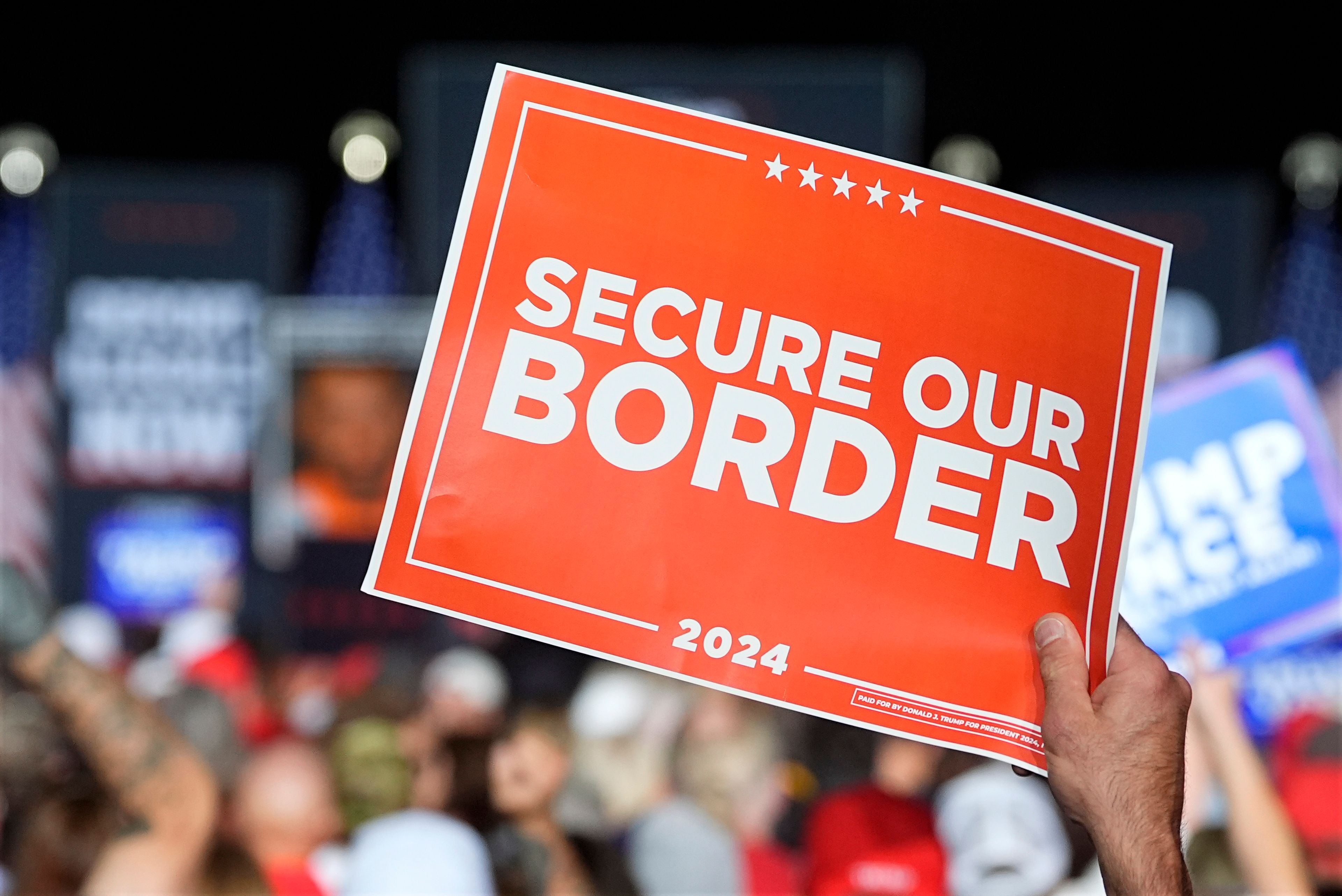 A supporter holds a 'Secure our Border' sign as Republican presidential nominee former President Donald Trump speaks at a campaign rally at the Gaylord Rockies Resort and Convention Center Friday, Oct. 11, 2024, in Aurora, Colo. (AP Photo/David Zalubowski)