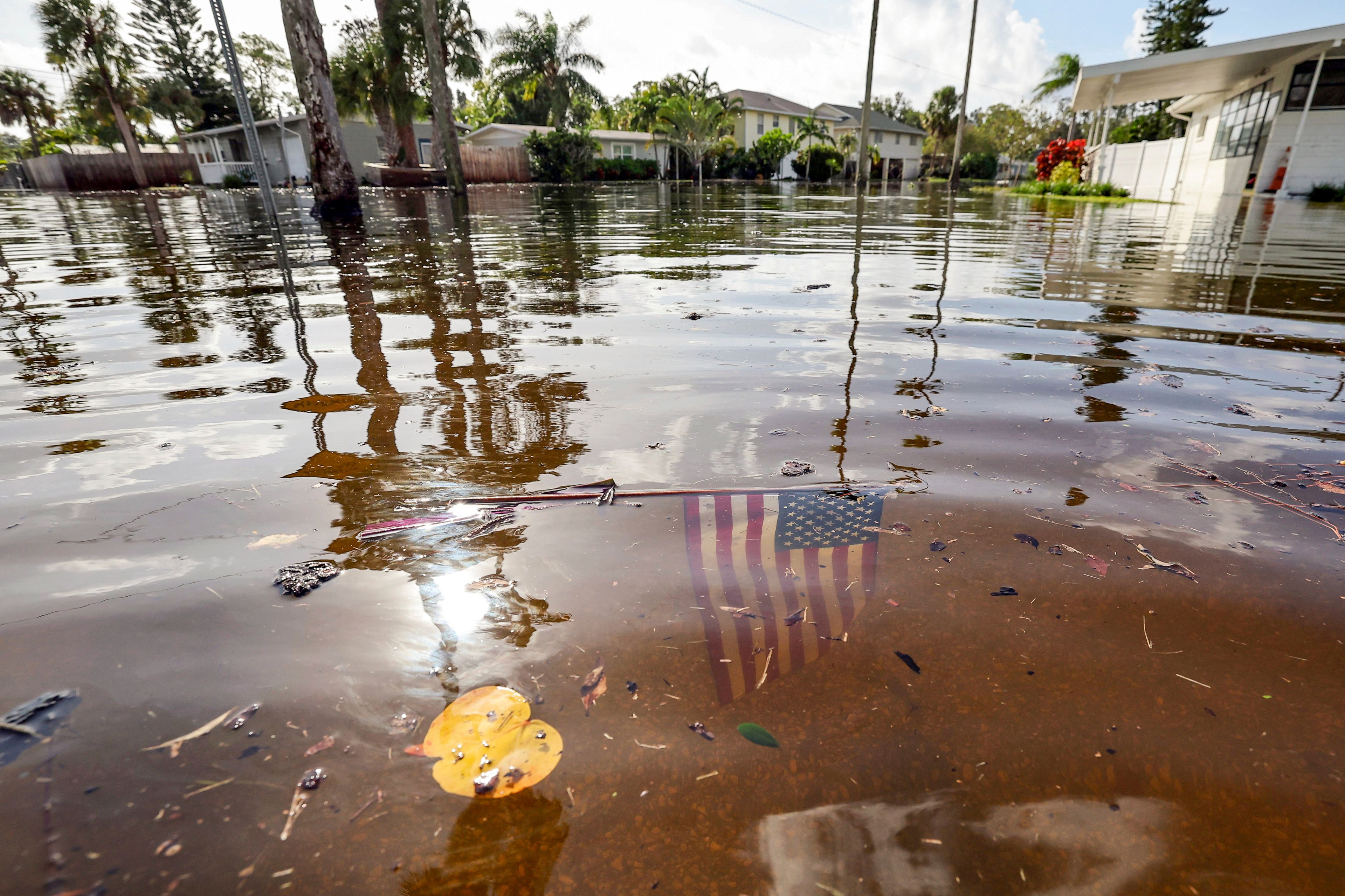 An American flag sits in floodwaters in the aftermath of Hurricane Helene in the Shore Acres neighborhood Friday, Sept. 27, 2024, in St. Petersburg, Fla. (AP Photo/Mike Carlson)