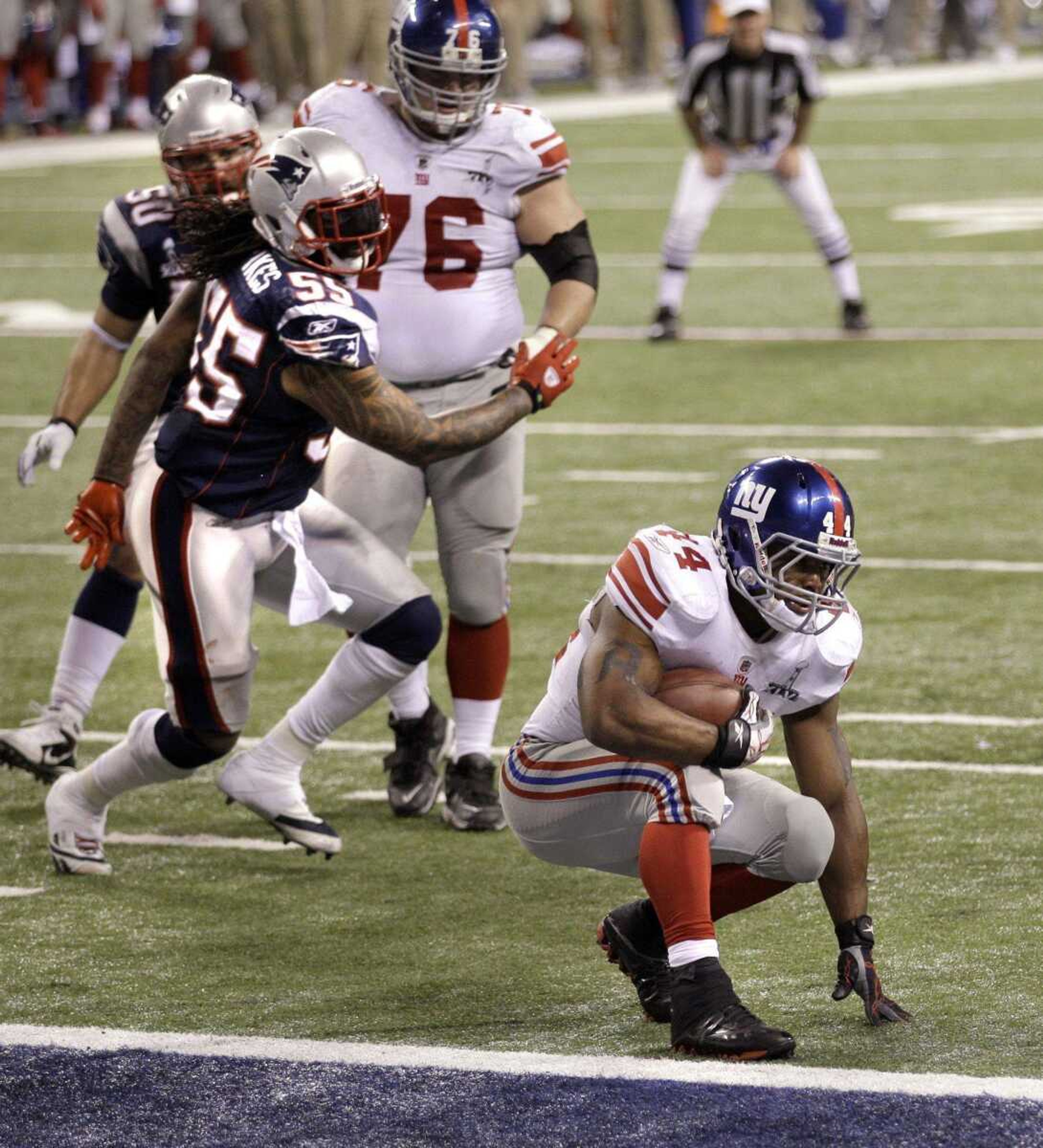 Giants running back Ahmad Bradshaw tries to fall down at the goal line before tumbling into the end zone during the final minute of Super Bowl XLVI. Bradshaw fell into the end zone for a touchdown. (David Duprey ~ Associated Press)