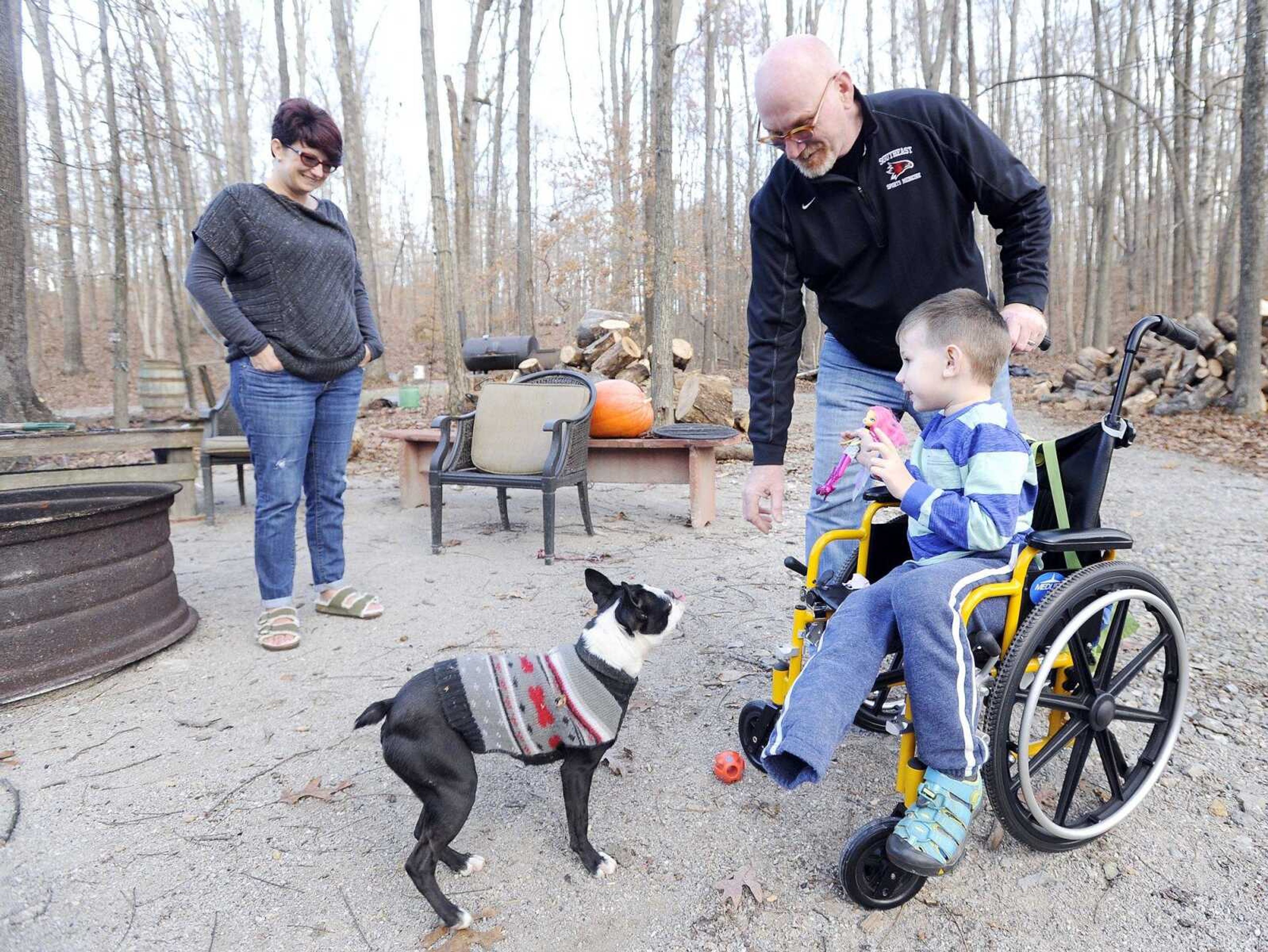 Vanessa, left, Brian, center, and Declan Stevens play Tuesday with their family dog, Millie, in Cape Girardeau County. (Laura Simon)