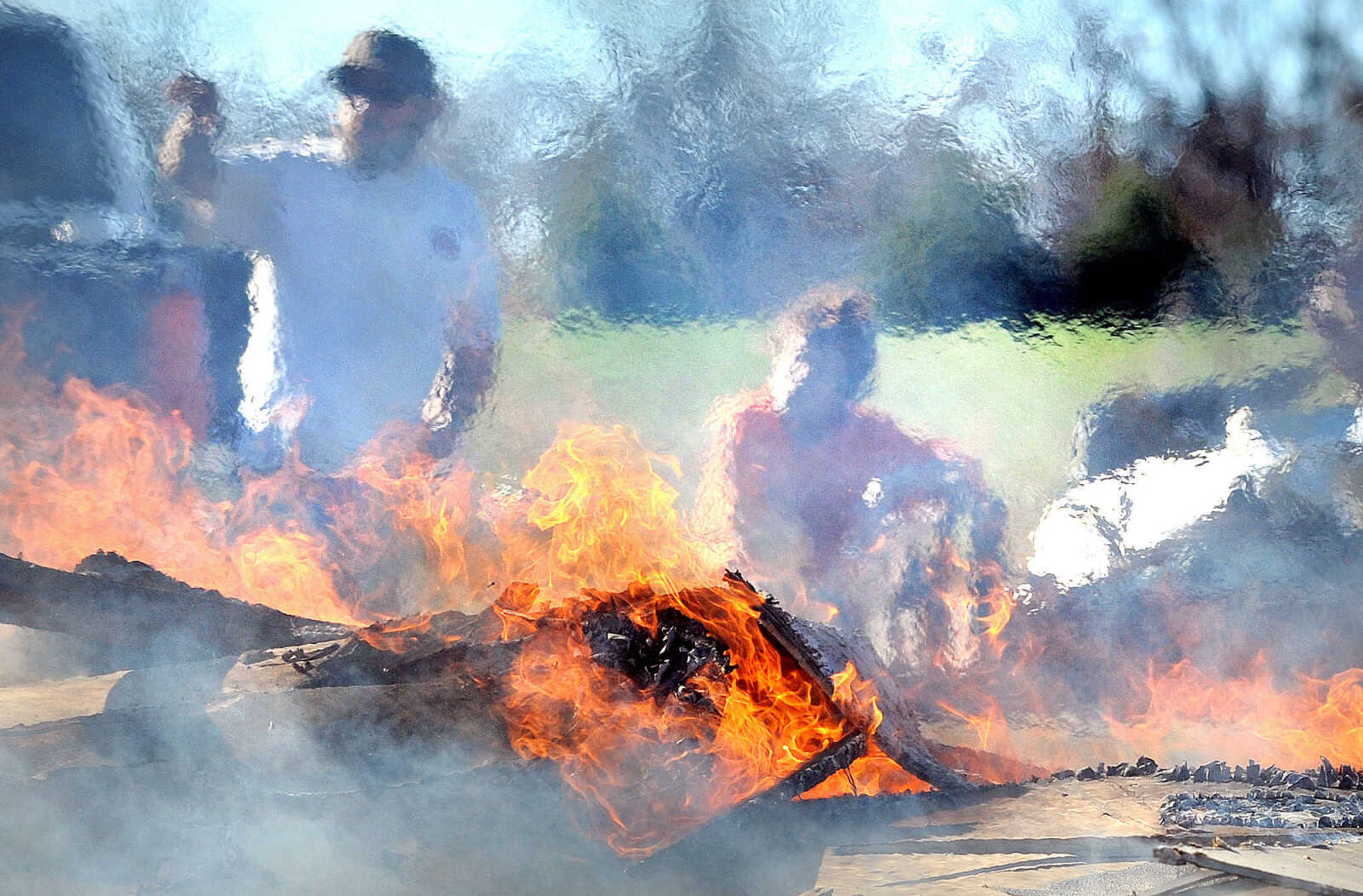 LAURA SIMON ~ lsimon@semissourian.com

Heat and smoke obscure Sharon Daniels, right and her son Thomas, as they burn the the remnants of her mobile home, Monday, Nov. 18, 2013, in Benton, Mo. Sharon Daniels recently purchased the mobile home near her family in a cul-de-sac off of Scott County Road 507. The mobile home moved around 20 feet off it's foundation during the severe weather that tore through the region on Sunday.