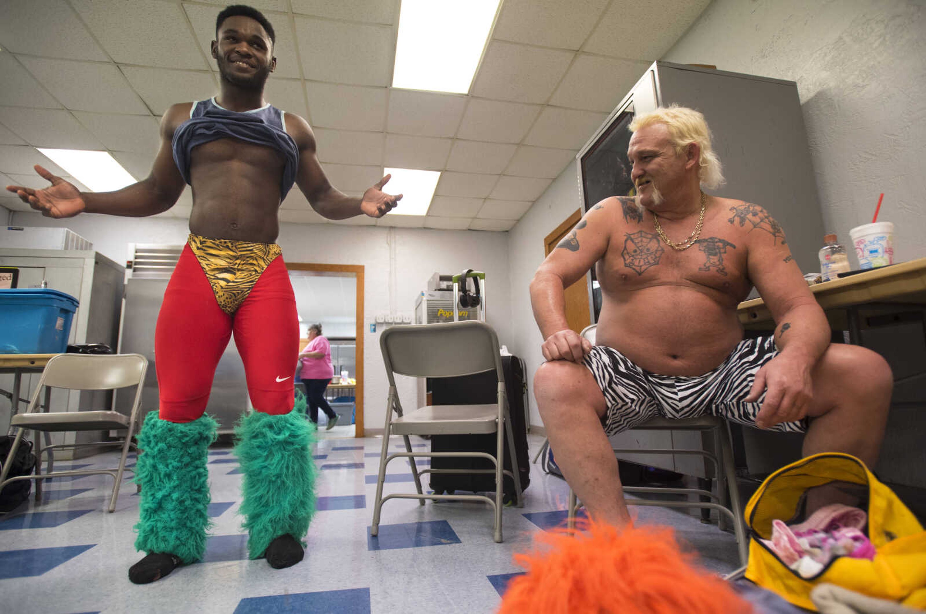 CCW wrestler Courtney "Bag Boy" Arnold models an outfit from the wardrobe of wrestler Sexy Sarge O'Riley, right, before a One Night Riot event begins Saturday, Feb. 24, 2018, at the Arena Building in Cape Girardeau.