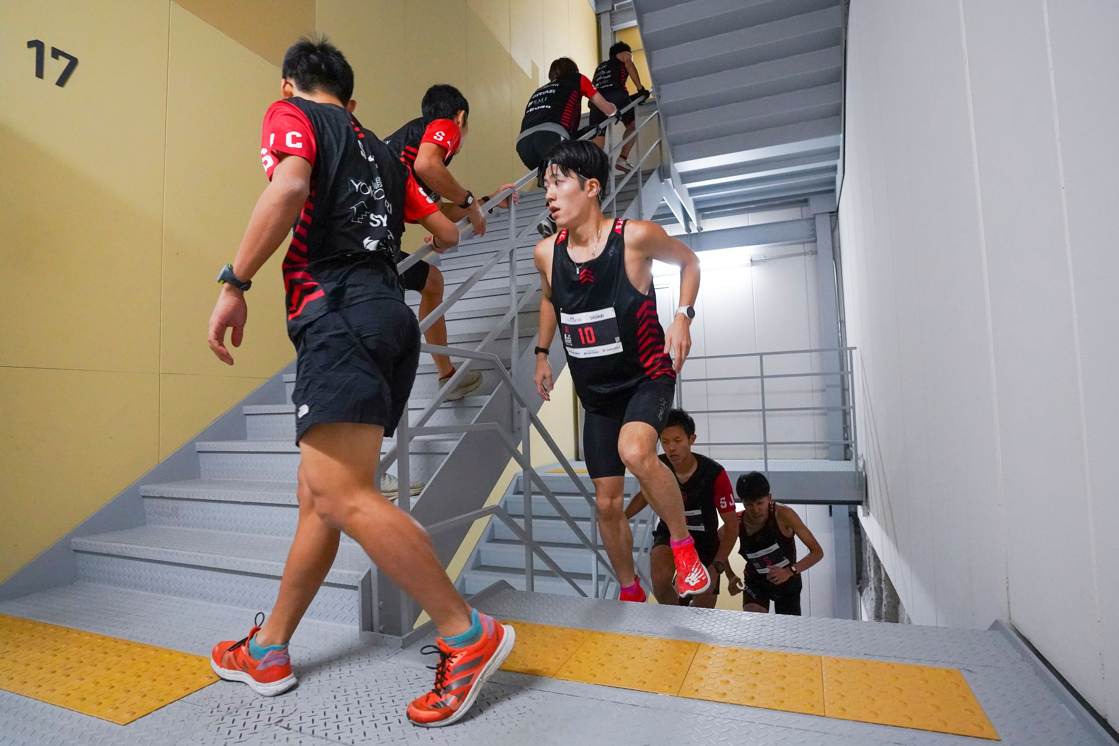 In this photo provided by ISF/Meeting, competitors climb stairs during a race of Stairclimbing World Championships in Osaka, western Japan, on Nov. 19, 2023. (ISF/MEETING via AP)