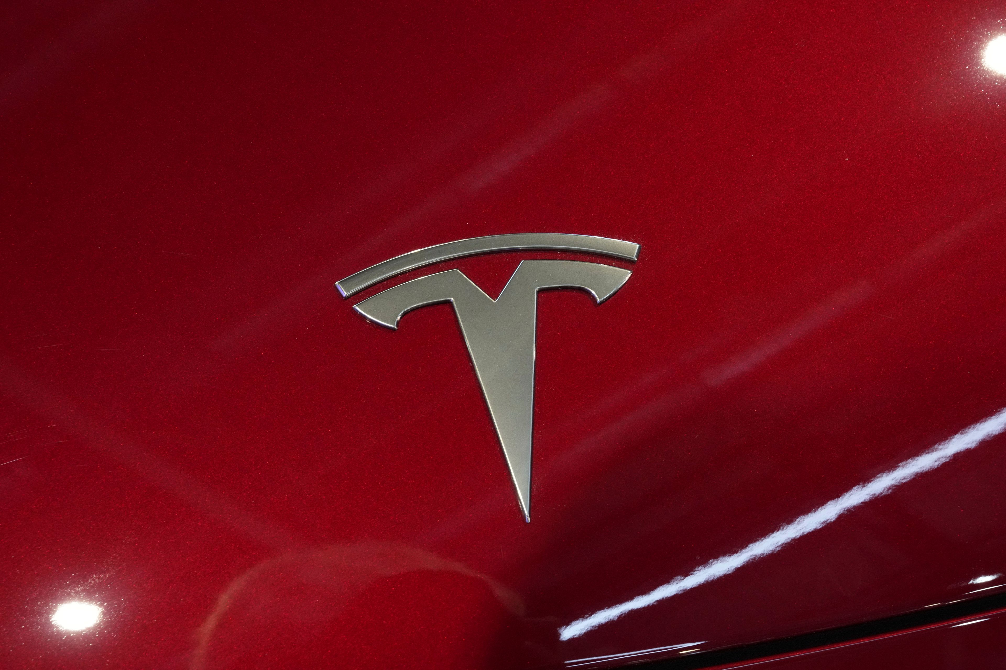 The logo of Tesla car is pictured at the Paris Auto Show, in Paris, Monday, Oct. 14, 2024. (AP Photo/Michel Euler)