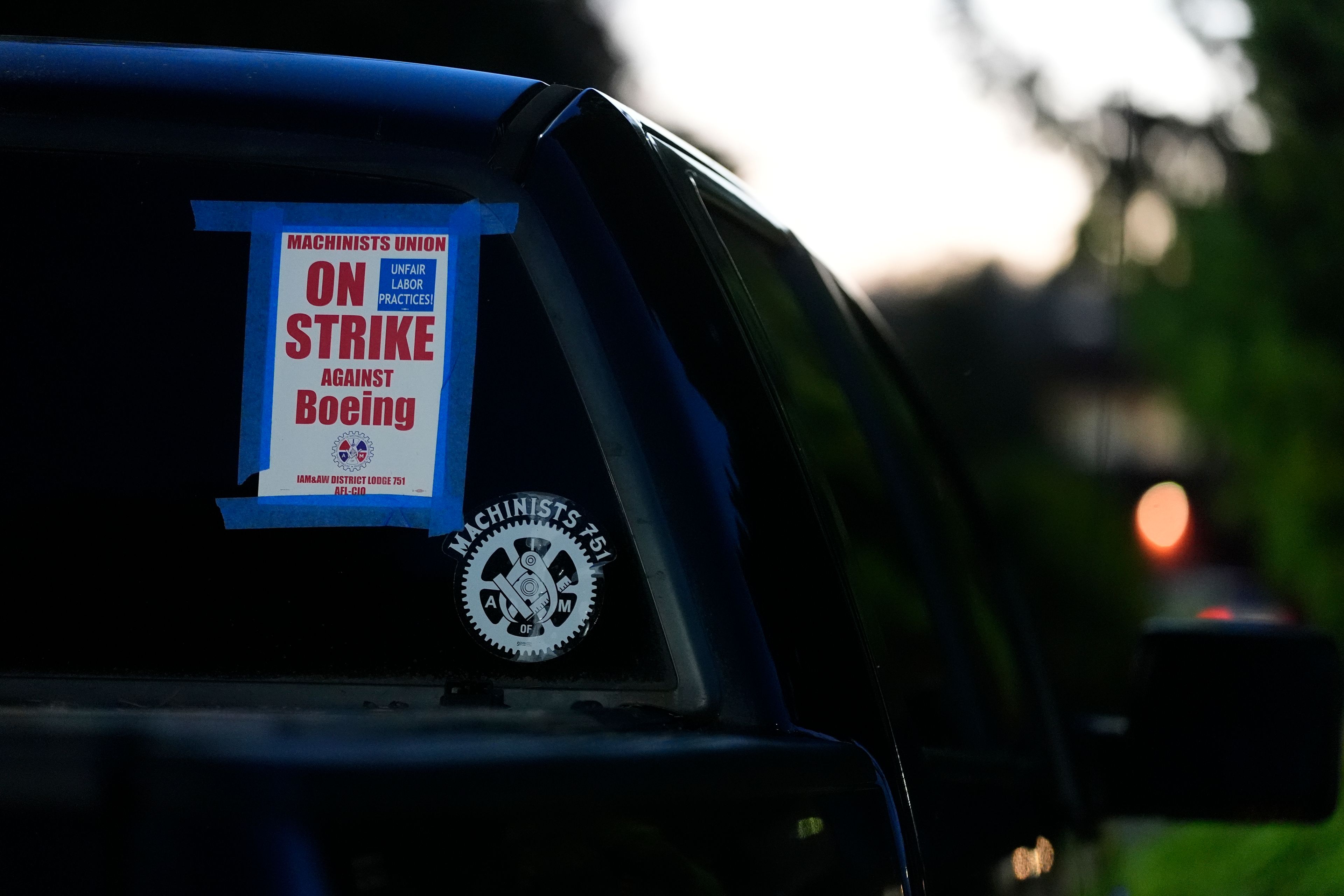 A truck displays a small strike sign in the parking lot of the Aerospace Machinists Union hall as Boeing employees arrive to vote on a new contract offer from the company Monday, Nov. 4, 2024, in Renton, Wash. (AP Photo/Lindsey Wasson)