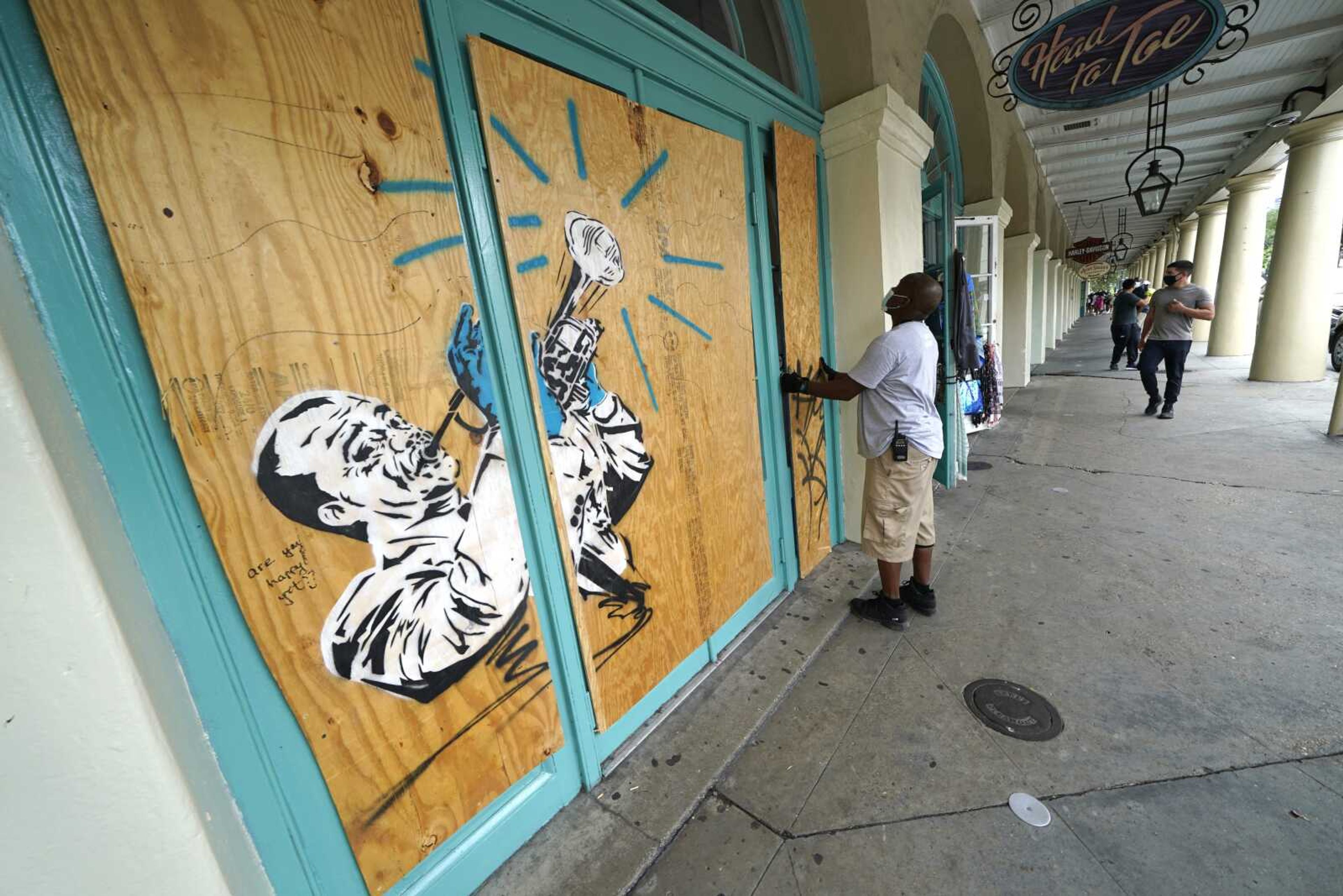 Workers board up shops in the French Quarter of New Orleans on Sunday in advance of Hurricane Marco, expected to make landfall on the Southern Louisiana coast.