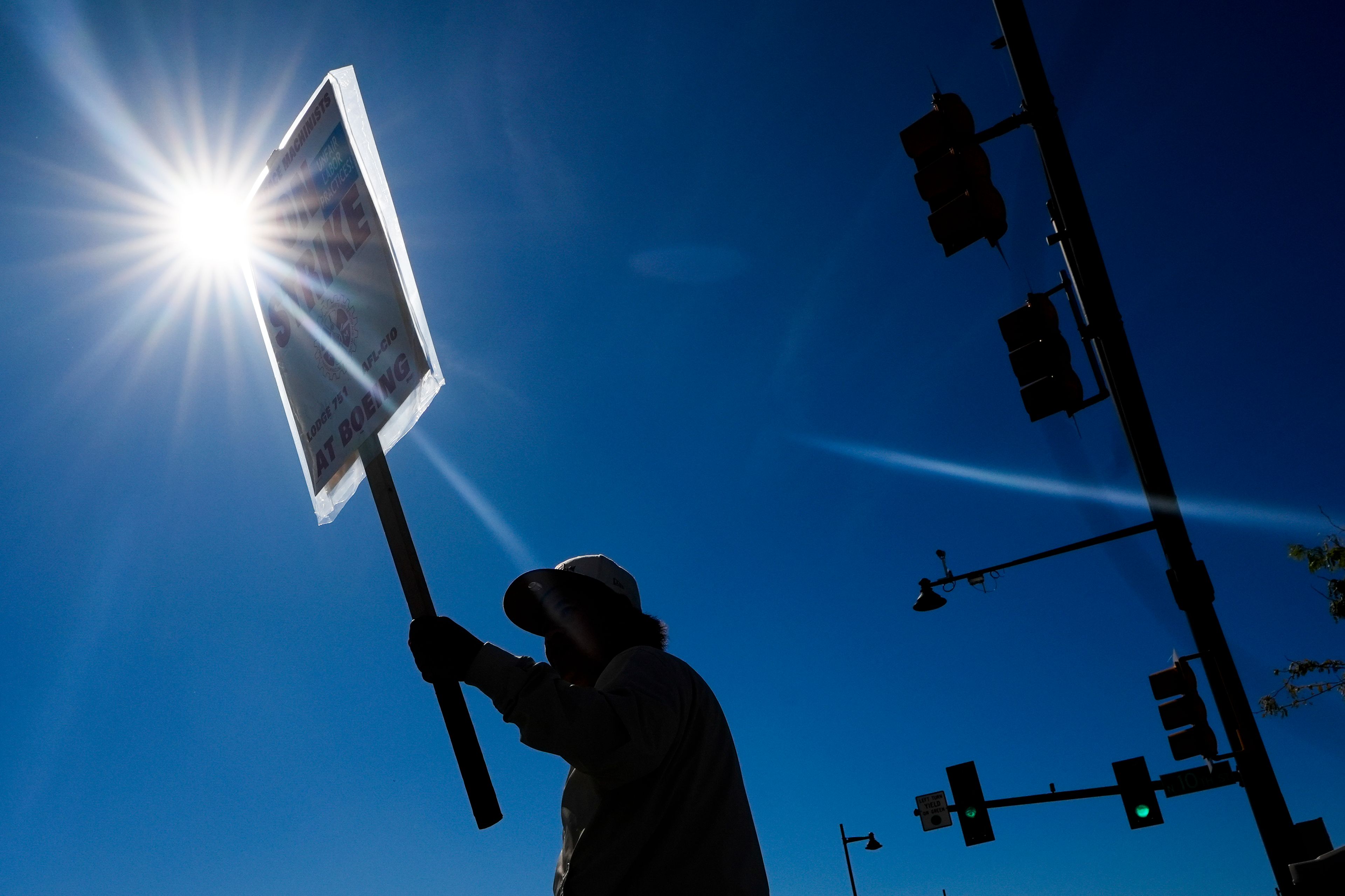 Boeing employee Som Dom, an electrician who has worked 17 years at Renton factory, holds a picket sign as workers strike Tuesday, Sept. 24, 2024, outside the company's factory in Renton, Wash. (AP Photo/Lindsey Wasson)