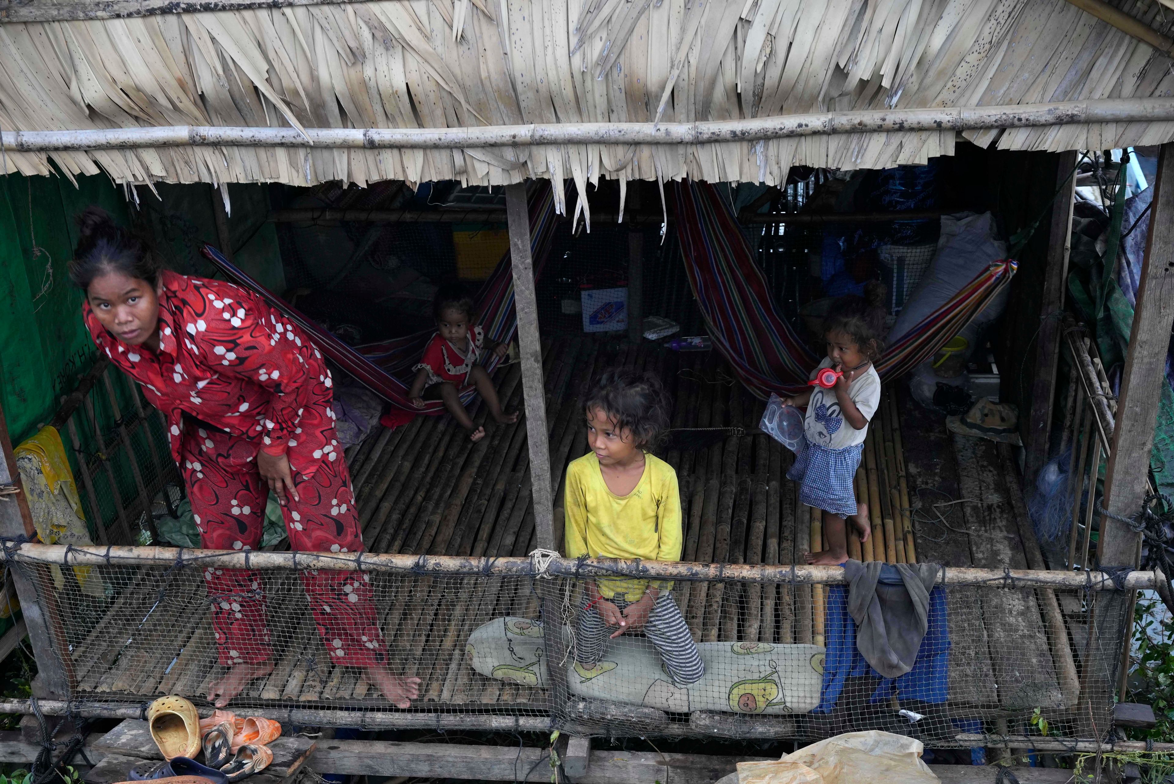 A fisher family in their home at a floating village, by the Tonle Sap in Kampong Chhnang province, Cambodia, Thursday, Aug. 1, 2024, (AP Photo/Heng Sinith)