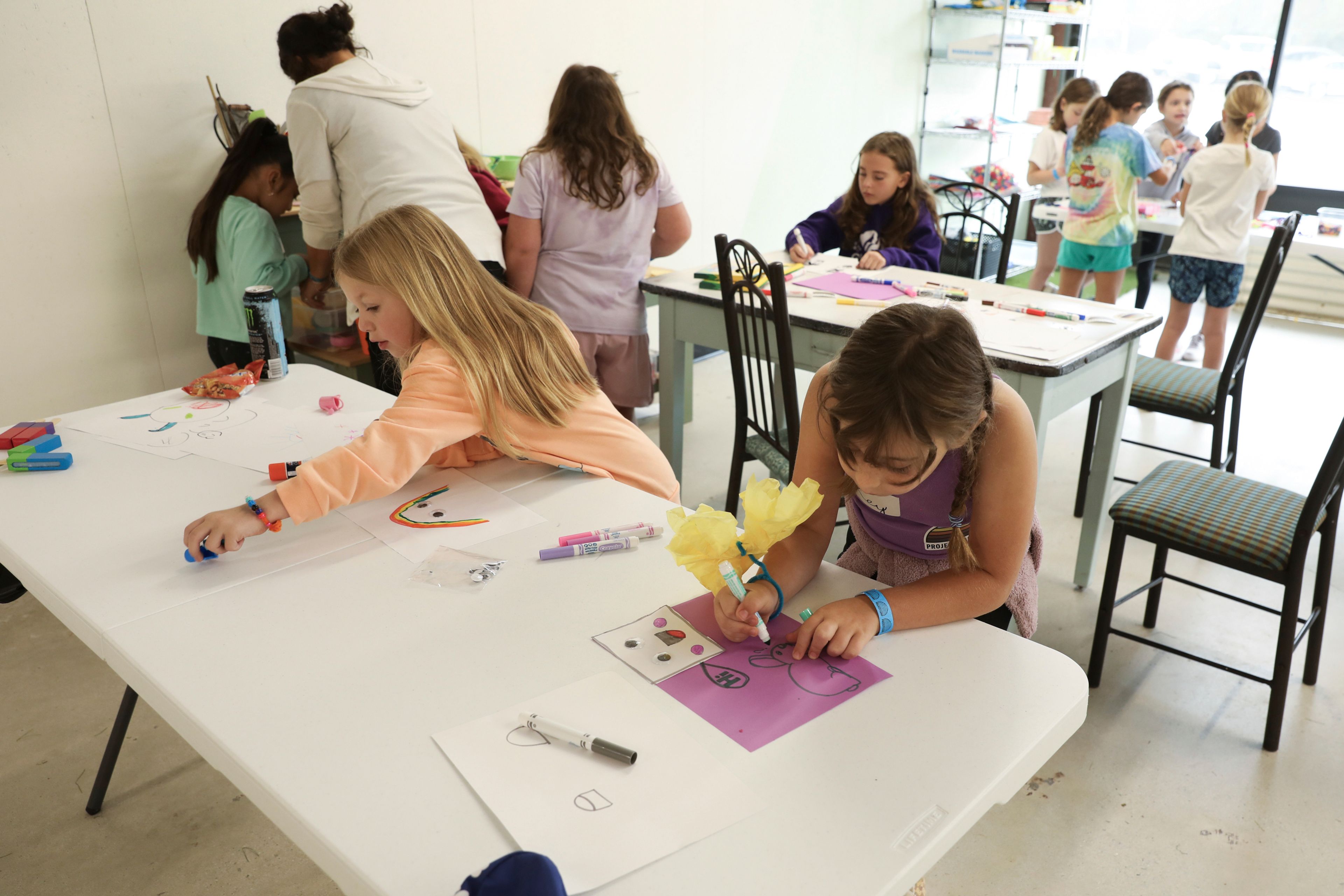 Seven-year-old Reyna Weissman, right, participates in arts and crafts, Monday, Oct. 7, 2024, at the Project:Camp pop-up daycamp for families impacted by Hurricane Helene in Brevard, N.C. (AP Photo/Gabriela Aoun Angueira)