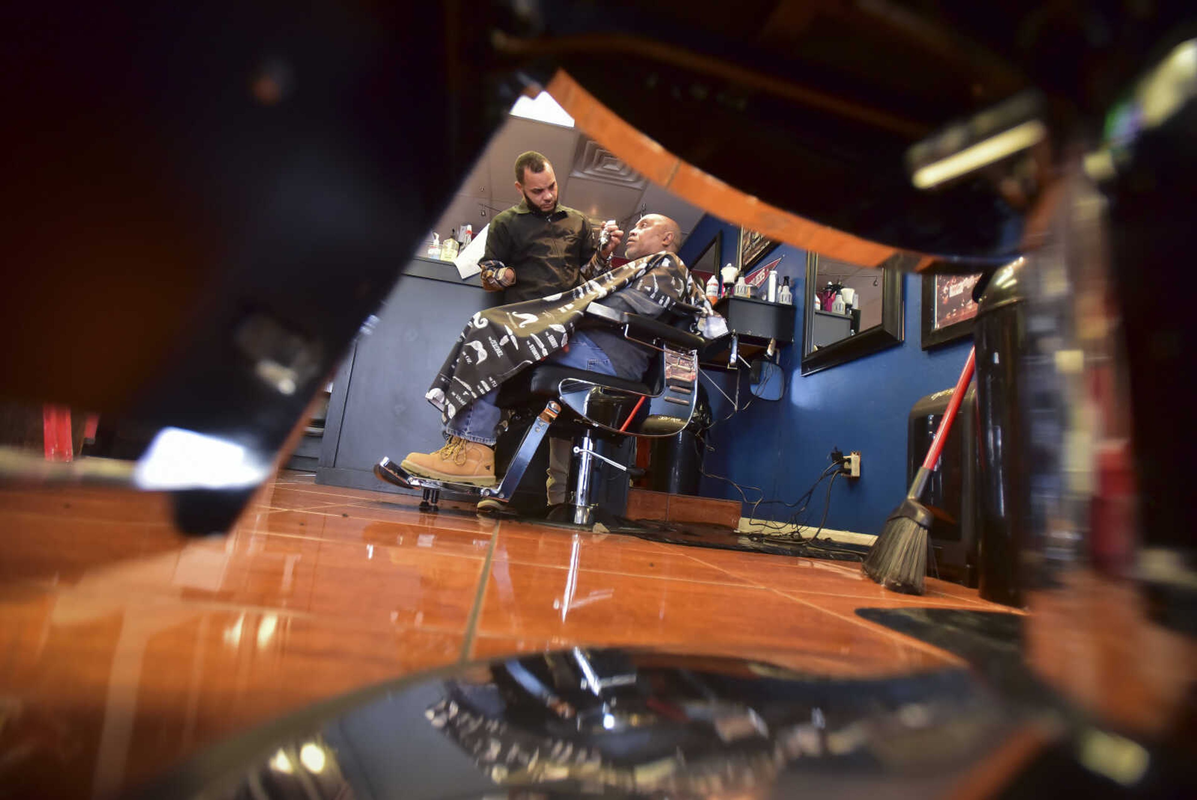 David Stewart sits in the barber chair as he gets a haircut by Chuck Reid at The Shop Friday, Jan. 6, 2017 at 821 Broadway in Cape Girardeau. Stewart has been coming to Reid ever since Reid was in barber school several years back.