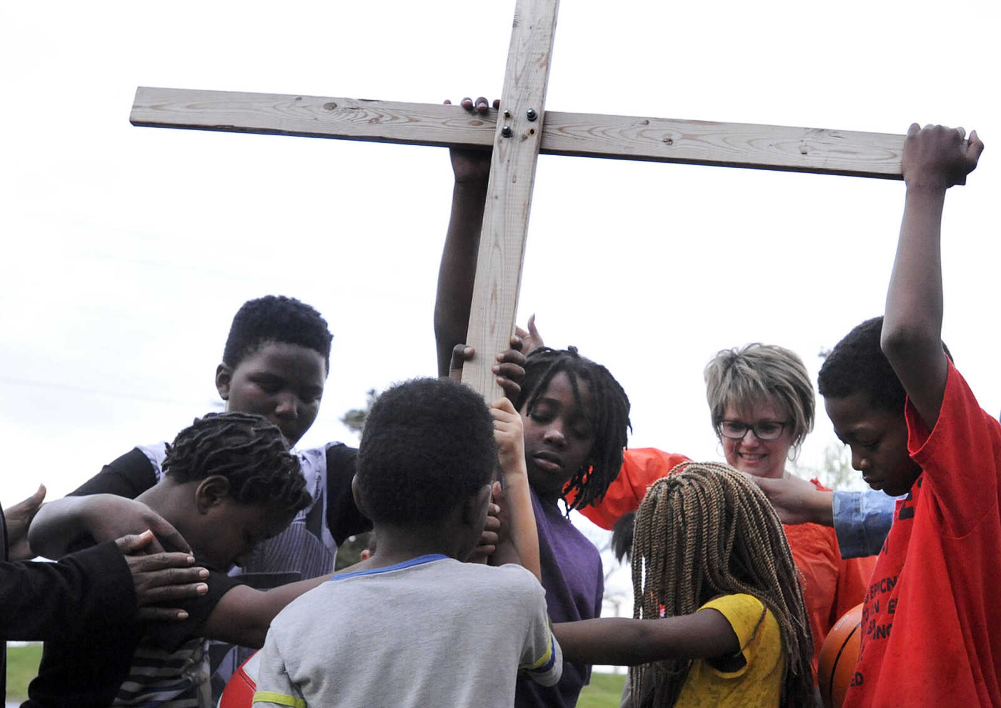 LAURA SIMON ~ lsimon@semissourian.com

Renita Lamkin smiles over neighborhood children as they join together in a prayer Thursday evening, April 14, 2016, during a prayer vigil on Locust Street in Cape Girardeau. Felice Roberson organized the vigil for Airious Darling who was shot and killed on Locust Street on March 31. Roberson's son Quinton Combs was shot and killed in November 2015 on Frederick Street.