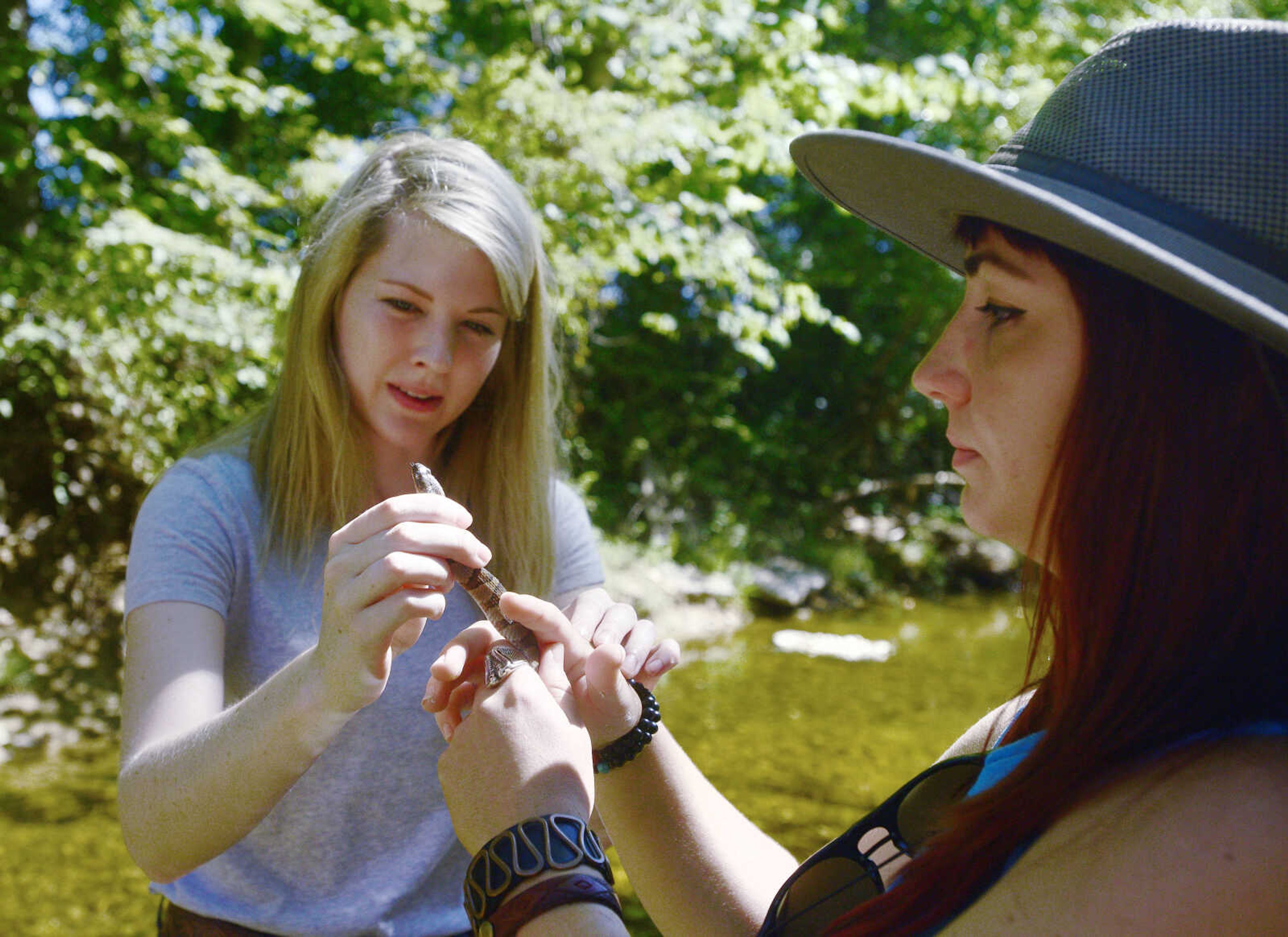 Jordyn Richmond, left, and Anna Mae Zembsch find a small Northern Water Snake in Little Indian Creek near Oriole, Missouri.