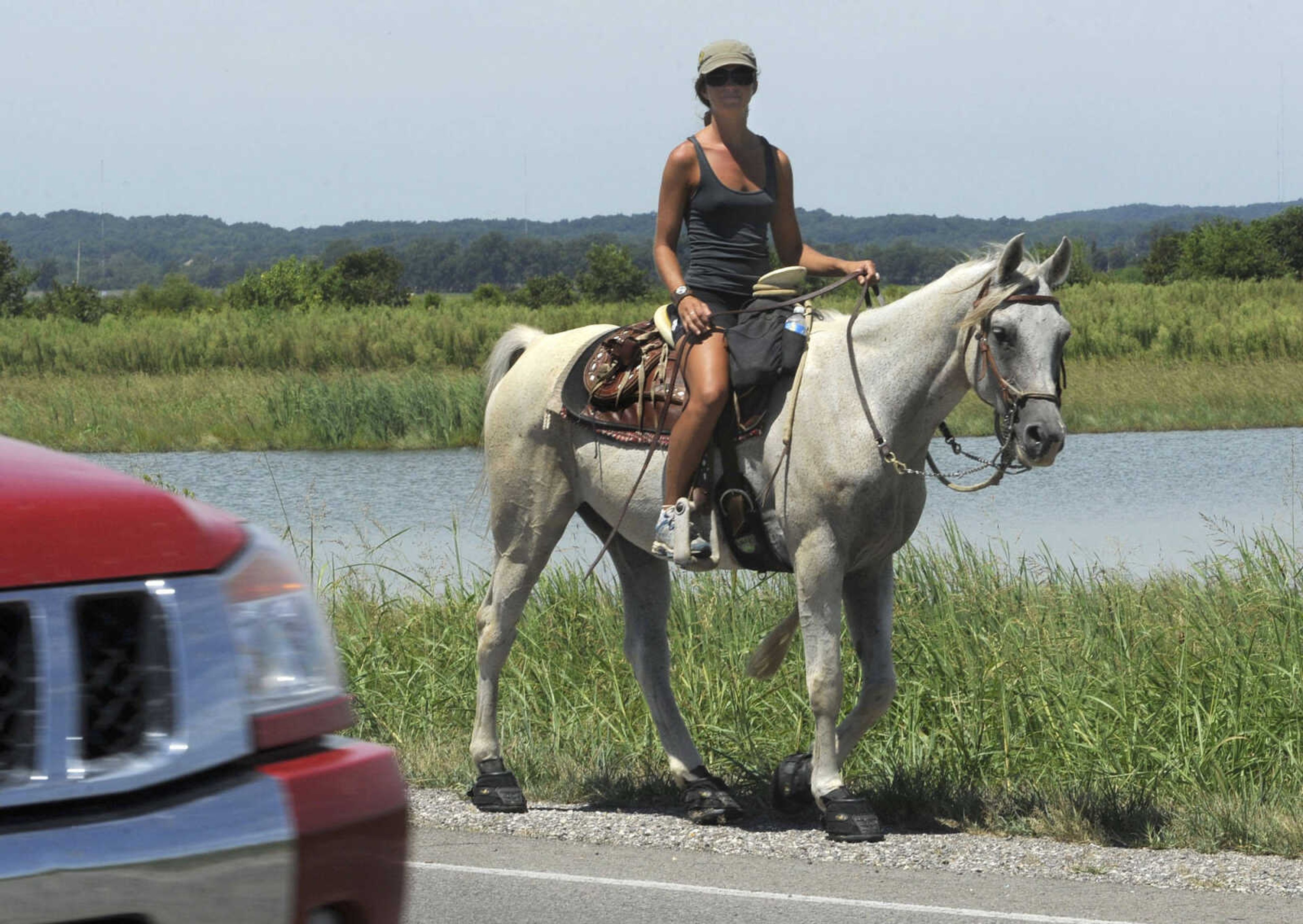 Linny Kenney rides her 11-year-old Arabian, Sojourner, along Highway 146 east of Cape Girardeau Tuesday, Aug. 17, 2010 while on her trip across America. She left San Francisco on March 1 and is heading to her childhood home in New Hampshire. According to Kenney's website, the ride is about endurance, challenge, a love for the land, people and the horse, and the beauty of slowing down to enjoy the moments. A video is available at semissourian.com. (Fred Lynch)