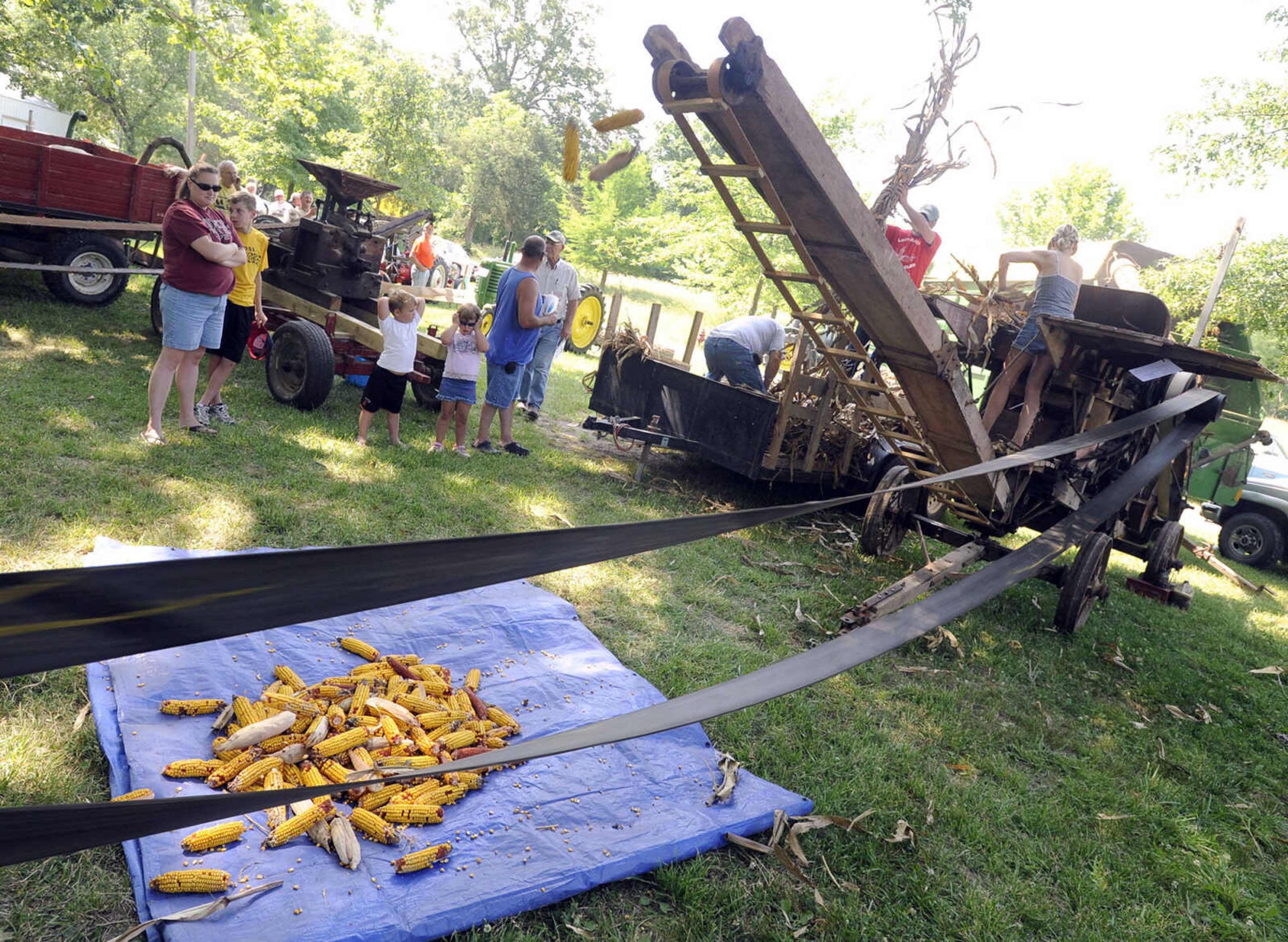 Pat Naeger and Joe Giesler demonstrate an Advance Rumely corn husker and shredder that was built about 1917 Saturday at Old Timers' Day in Perryville, Mo.