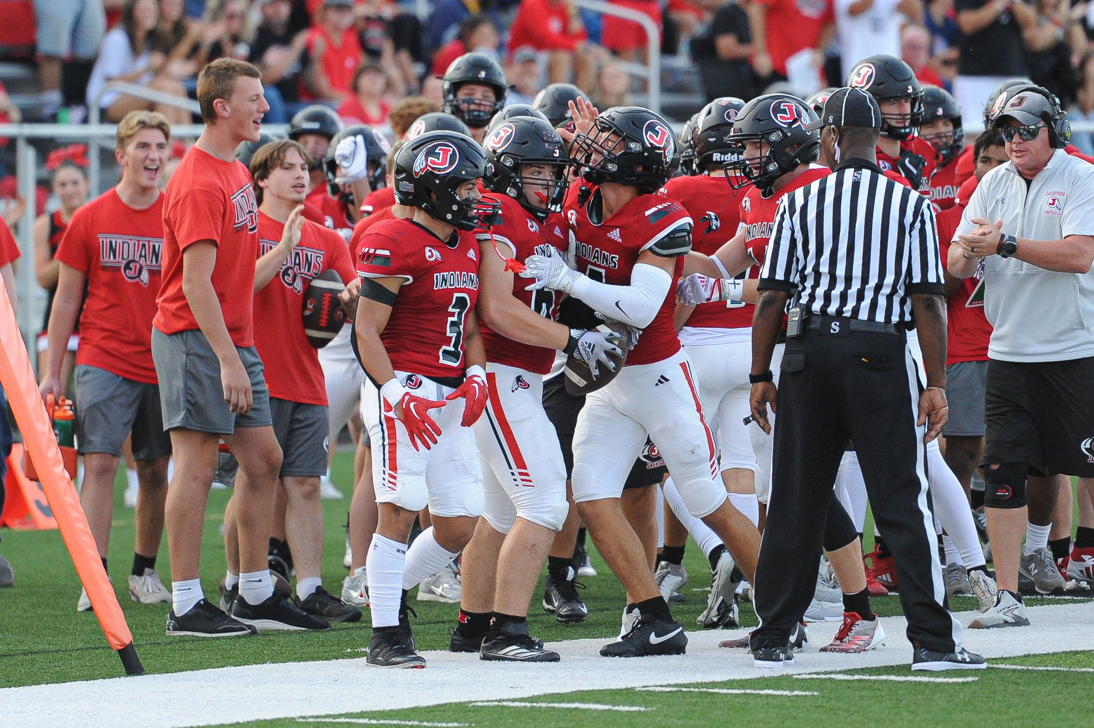 Jackson's Marcus Cutsinger is greeting by teammates after a pick during a Saturday, September 14, 2024 game between the Edwardsville Tigers and the Jackson Indians at Edwardsville High School in Edwardsville, Ill. Edwardsville defeated Jackson, 41-7.