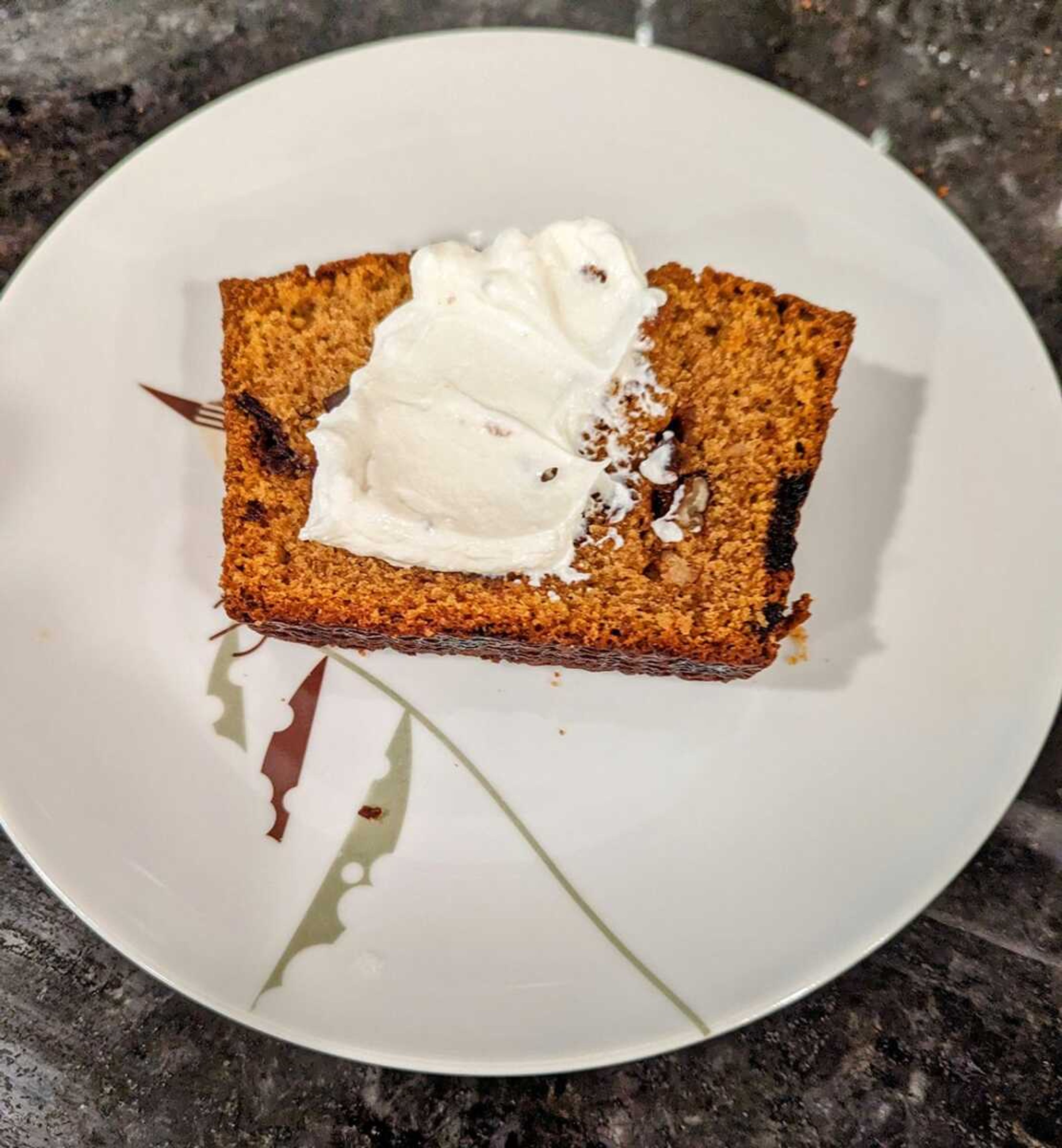 A slice of pumpkin bread adorned with cream cheese, a treat at the holidays or any time of the year.