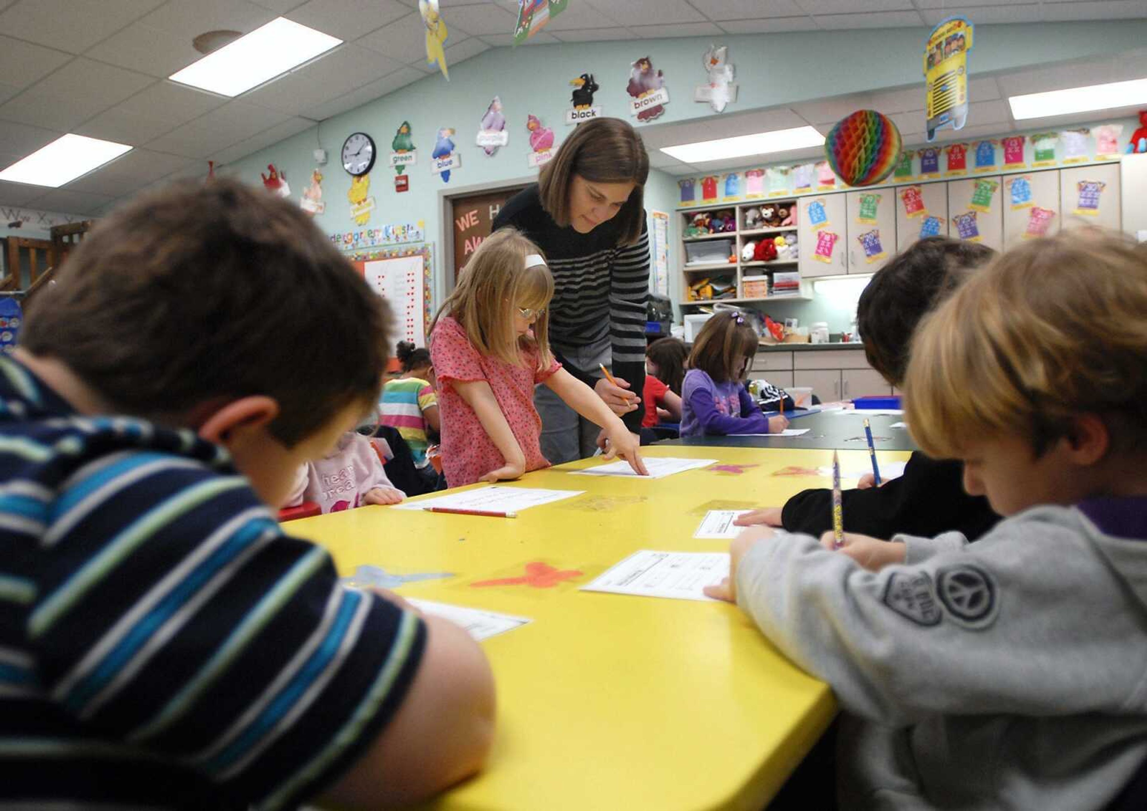 Kindergarten teacher Crystal Williams checks over a worksheet with student Tabitha Slinkard, center, during class on Thursday, Feb. 24, 2011, at Blanchard Elementary School in Cape Girardeau. Williams teaches a class of 24 kindergarten students. (Kristin Eberts)