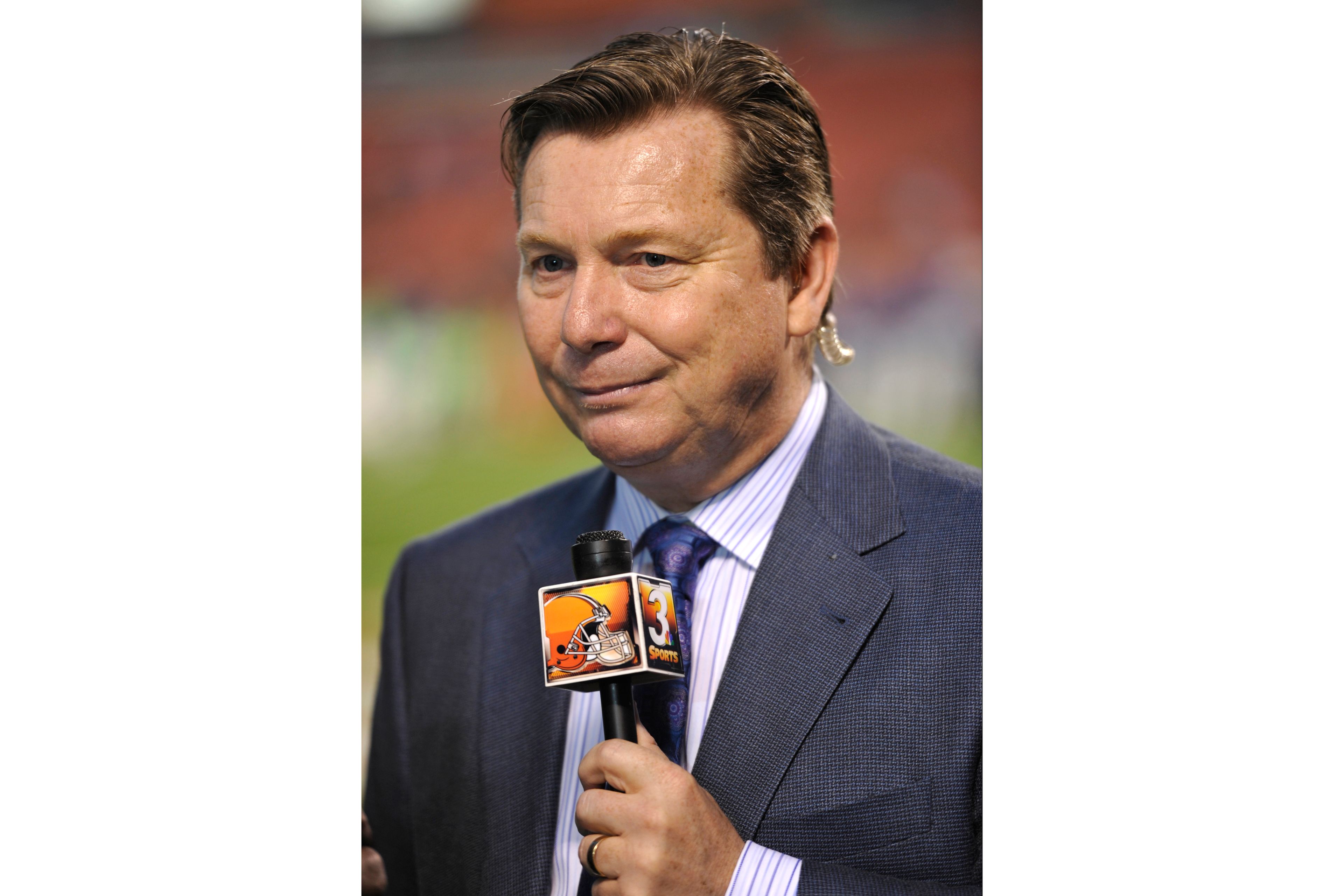 FILE _ Cleveland Browns radio broadcaster Jim Donovan stands on the field prior to an NFL football game against the Buffalo Bills on Thursday, Oct. 3, 2013 in Cleveland. The Browns won 37-24. (AP Photo/David Richard, File)