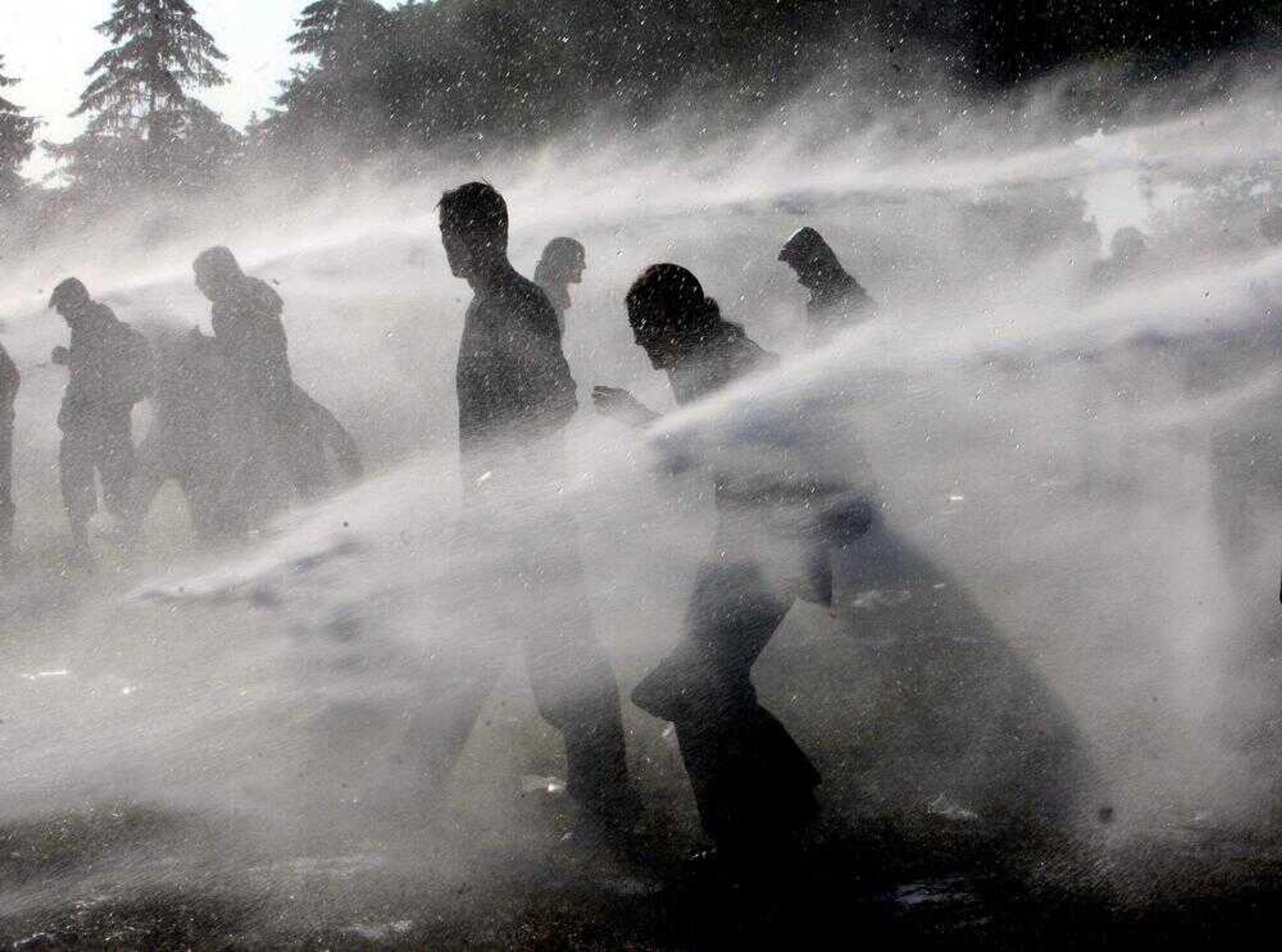 German police used water cannons Thursday to keep demonstrators off a fence near Heiligendamm, Germany. The leaders of the G-8 nations are holding their annual summit in the historic Heiligendamm sea resort through today. (Michael Probst ~ Associated Press)