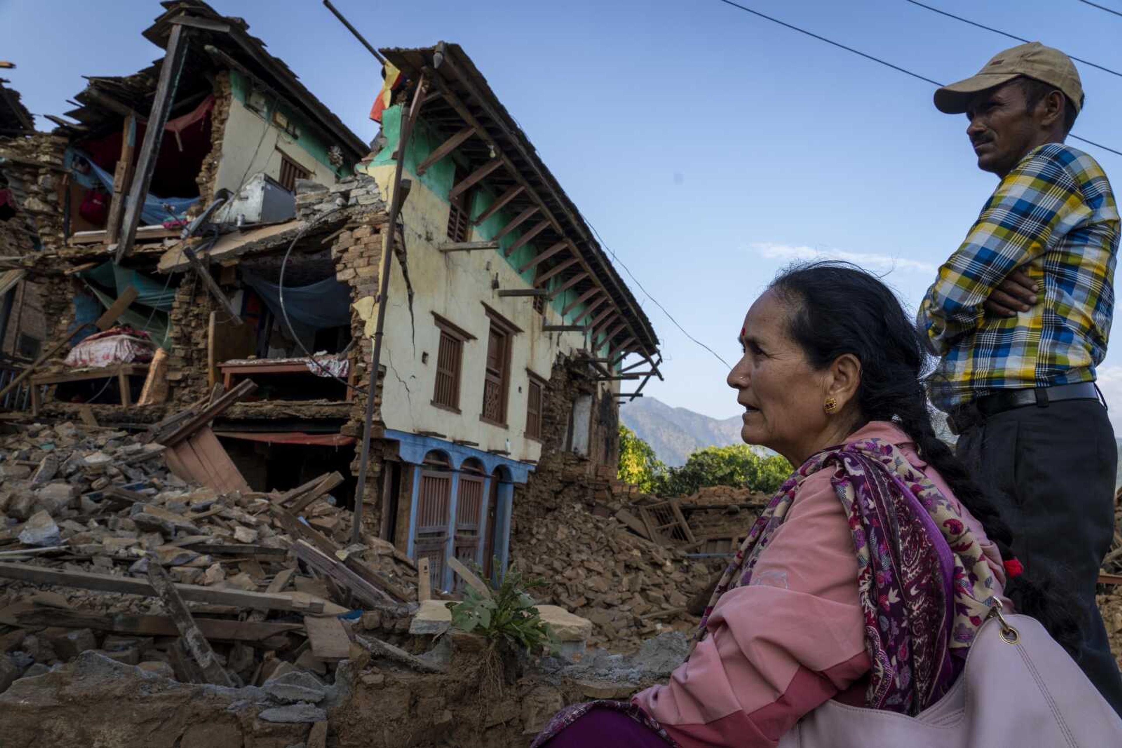 A woman sits in front of her earthquake damaged house Sunday in Jajarkot district, northwestern Nepal. Friday night's earthquake killed more than 10 people in the district while more than 50 were killed in the neighboring Rukum district, officials said.