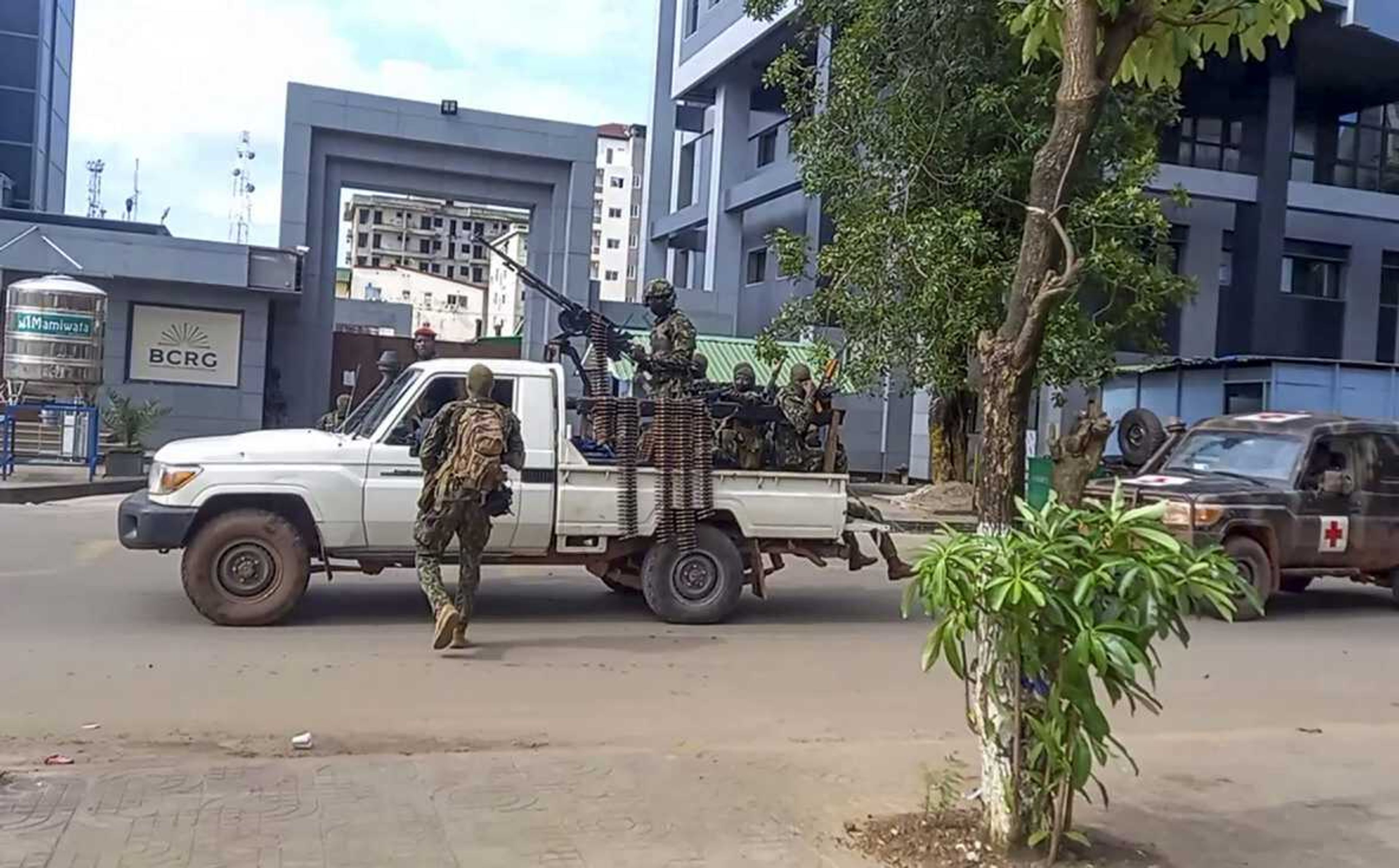 In this image made from video, unidentified soldiers patrol in a vehicle near the office of the president Sunday in the capital Conakry, Guinea.