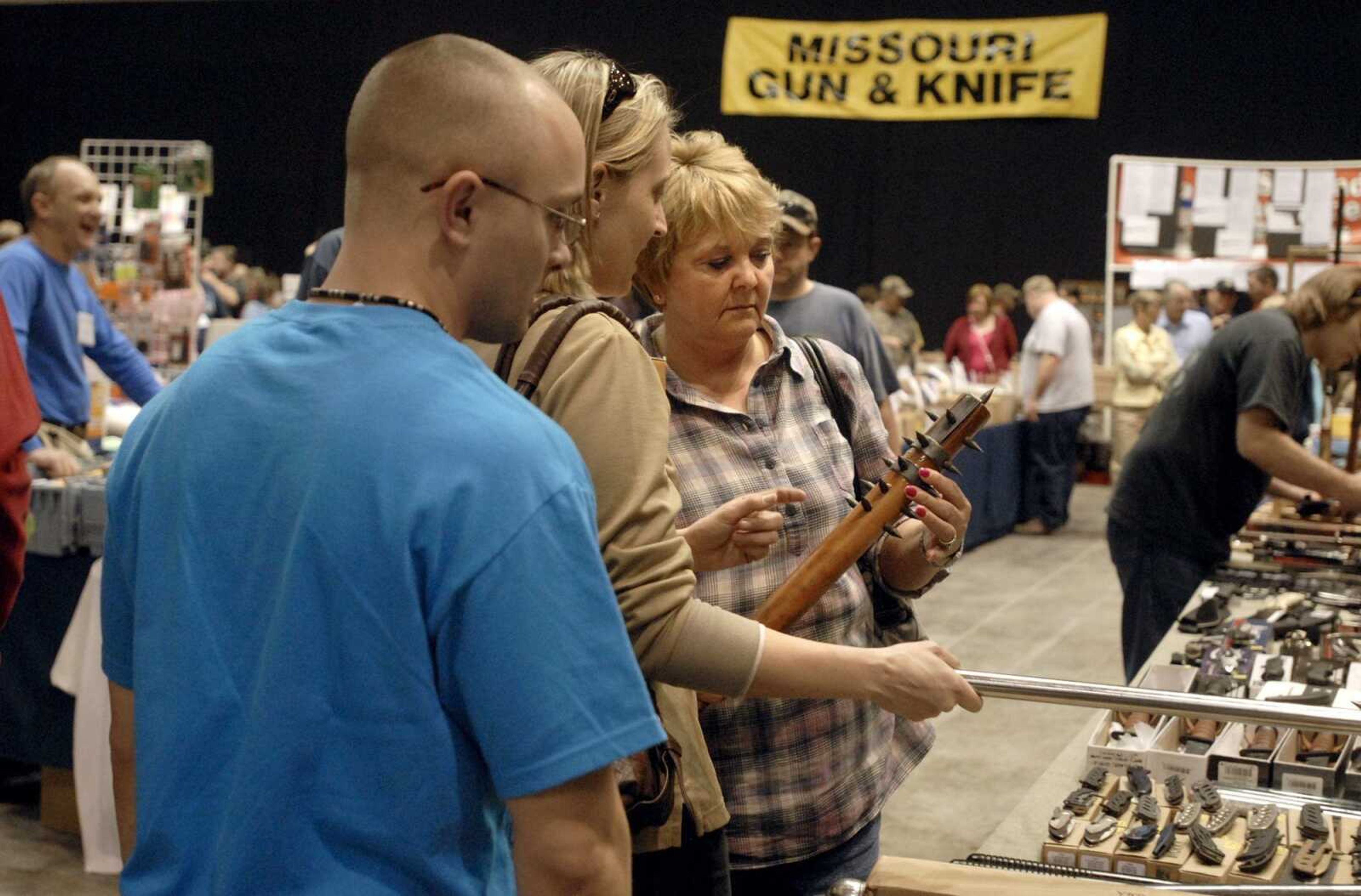 Carla Martin of Marion, Il. looks at a spike mace with her children Melanie and Joshua Saturday, March 12, 2011 during the Missouri Gun and Knife Show at the Show Me Center in Cape Girardeau. (Laura Simon)