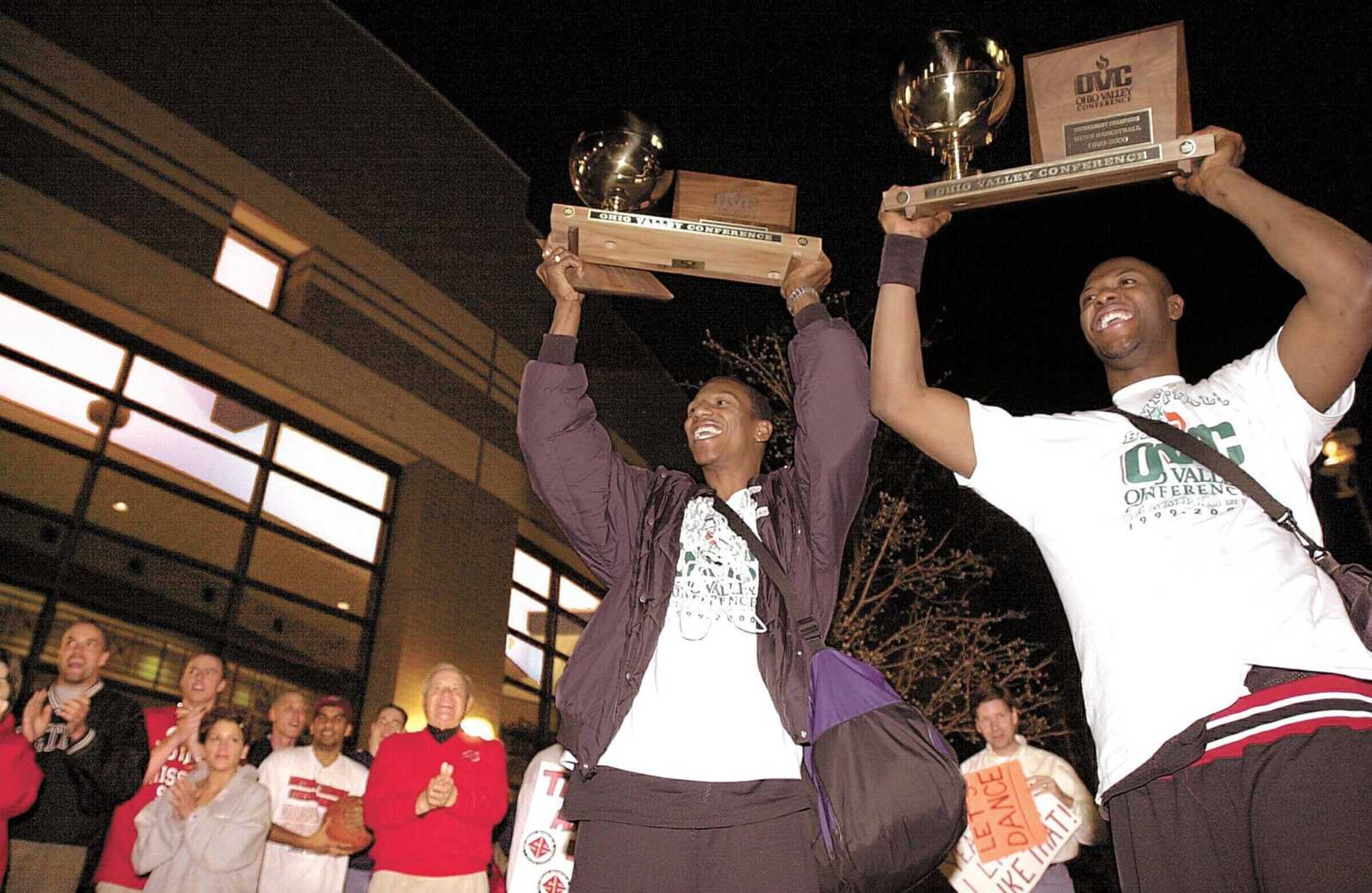 Southeast Missouri State seniors Roderick Johnson, center, and Brian Bunche, right, display the MVP and OVC Championship trophies after arriving back at the Show Me Center following a defeat of Murray State to clinch a first-ever berth in the NCAA tournament for the university. (Southeast Missourian ~ Chris Stanfield)