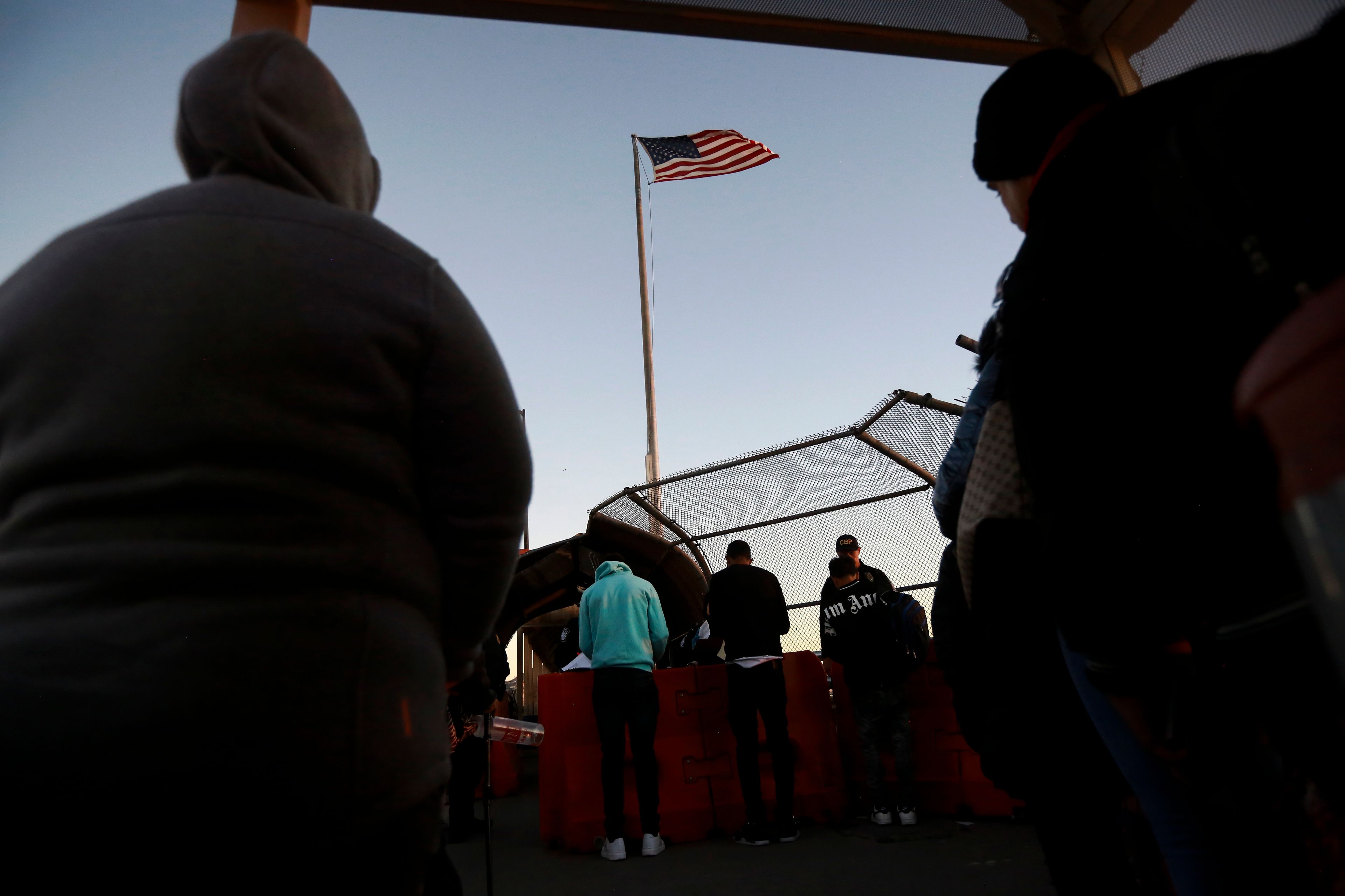 FILE - Migrants line up to present to U.S. agents, documents requesting an appointment to apply for asylum, at the Paso del Norte international bridge, in Ciudad Juarez, Mexico, Nov 5, 2024. (AP Photo/Christian Chavez, File)