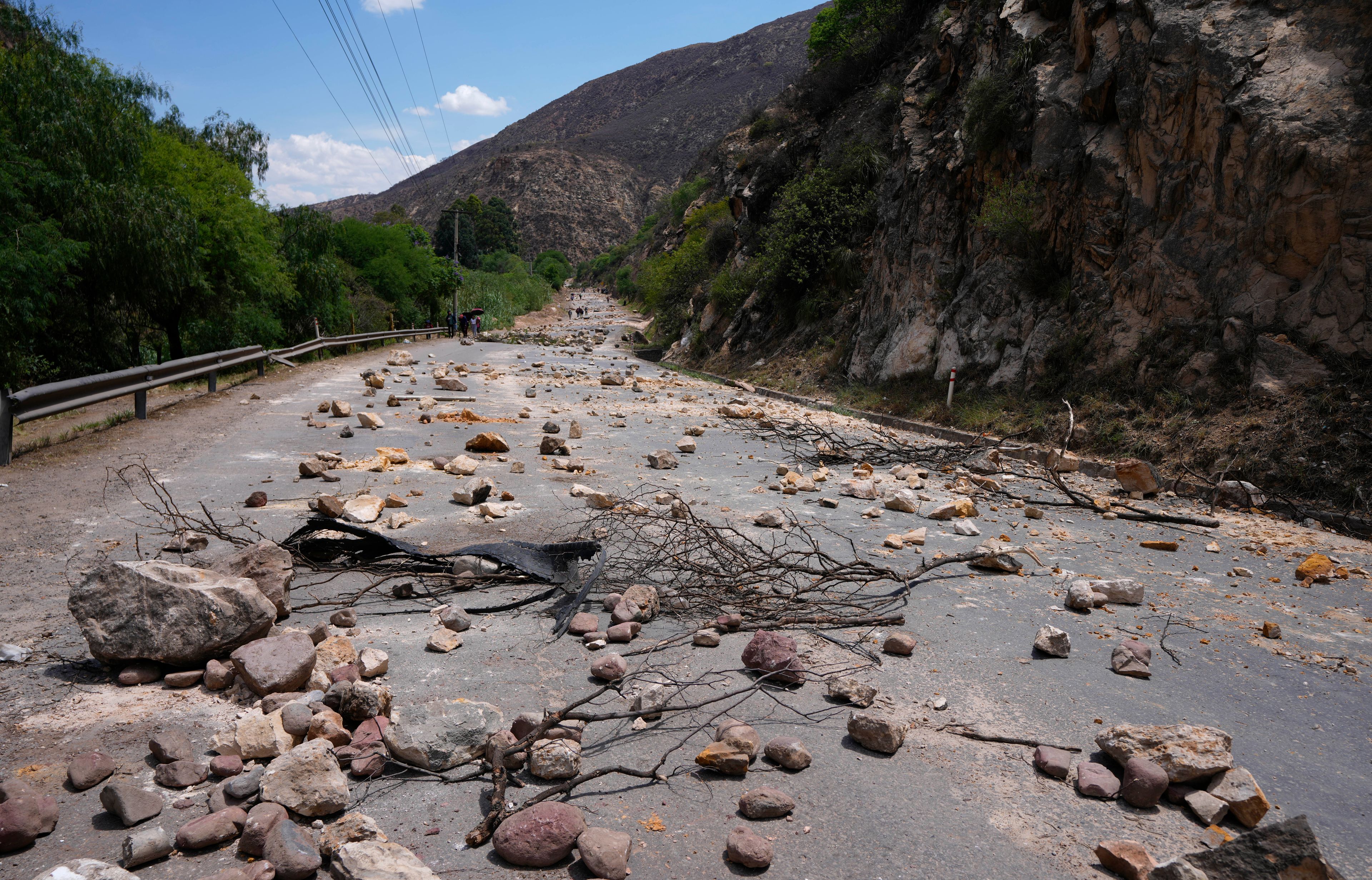 Stones and debris lie on the road after supporters of Bolivian former President Evo Morales placed them there to prevent him from facing a criminal investigation over allegations of abuse of a minor and to demonstrate against an alleged assassination attempt, near Cochabamba, Bolivia, Sunday, Oct. 27, 2024. (AP Photo/Juan Karita)