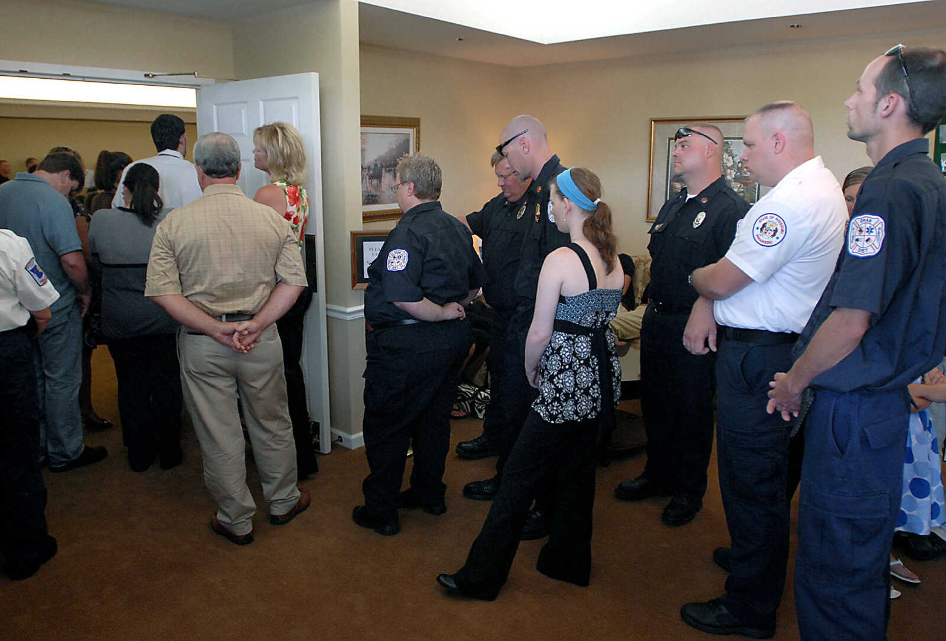 Emergency personnel listen to the Alexis Cummins funeral service from outside the chapel Wednesday, June 3, 2009, at Ponder Funeral Home in Sikeston.