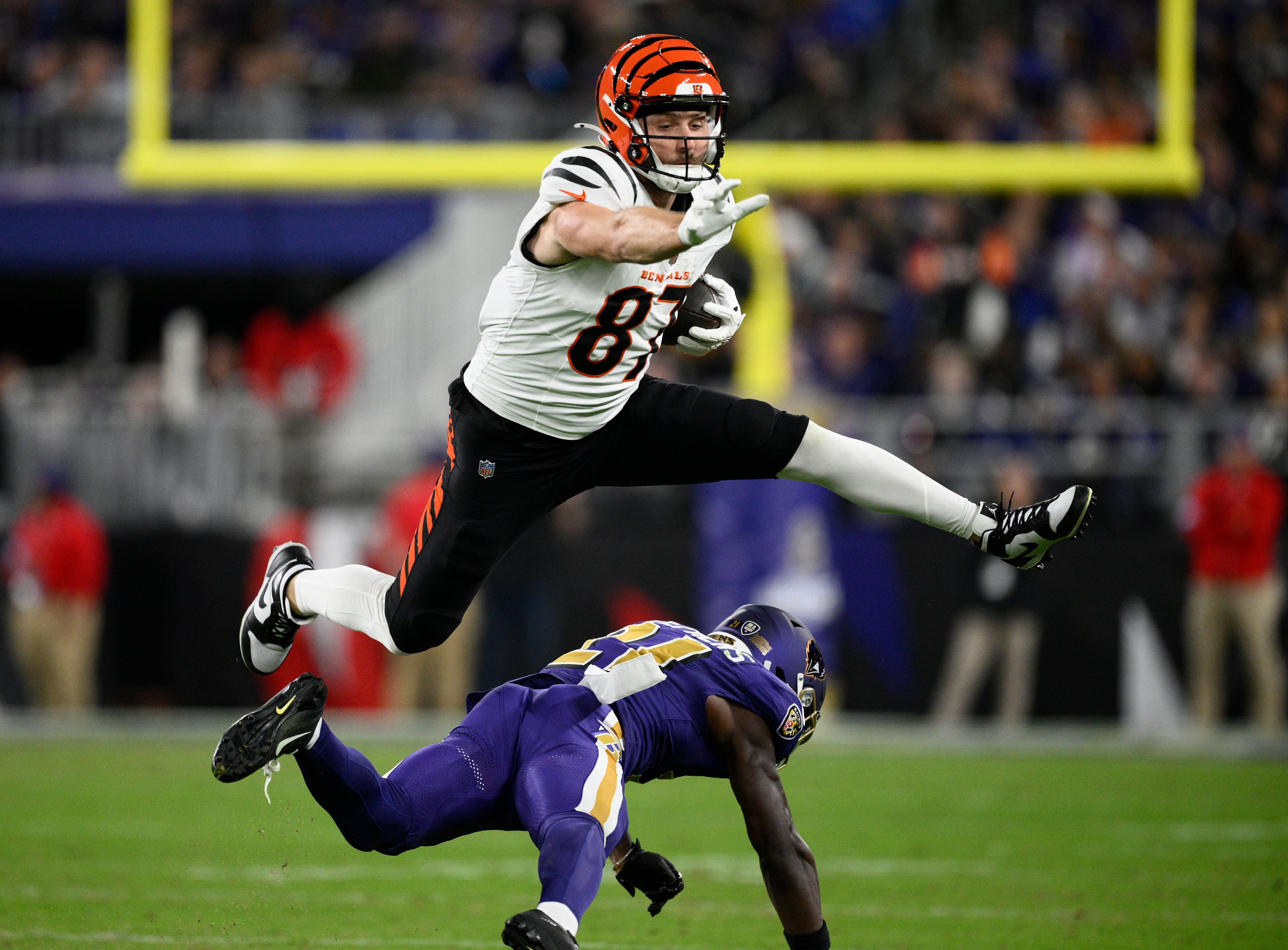 Cincinnati Bengals tight end Tanner Hudson (87) hurdles Baltimore Ravens cornerback Brandon Stephens (21) during the first half of an NFL football game, Thursday, Nov. 7, 2024, in Baltimore. (AP Photo/Nick Wass)