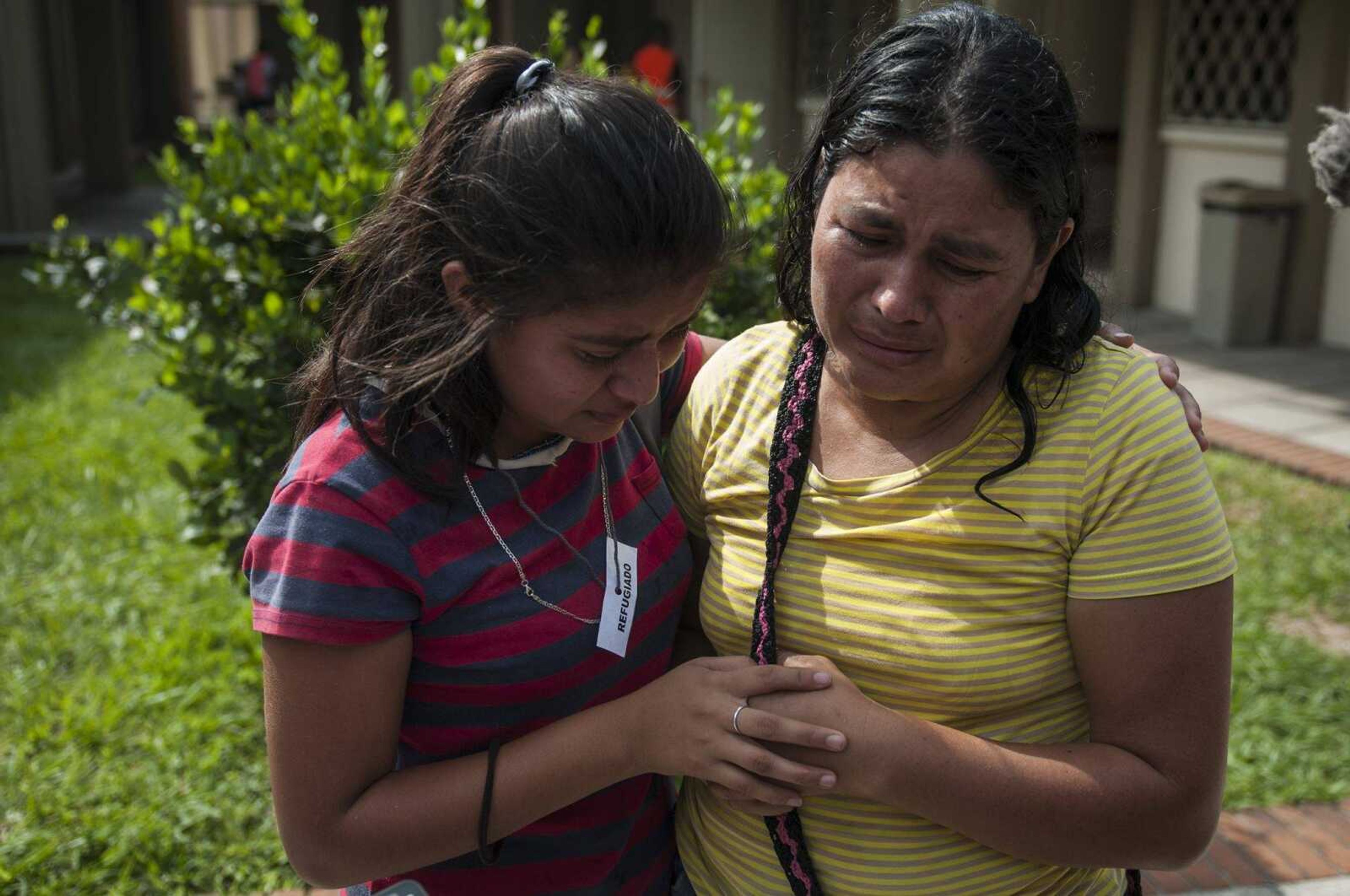 Lilian Hernandez, right, is comforted by her daughter Tuesday at a Mormon church serving as a shelter near Escuintla, Guatemala.